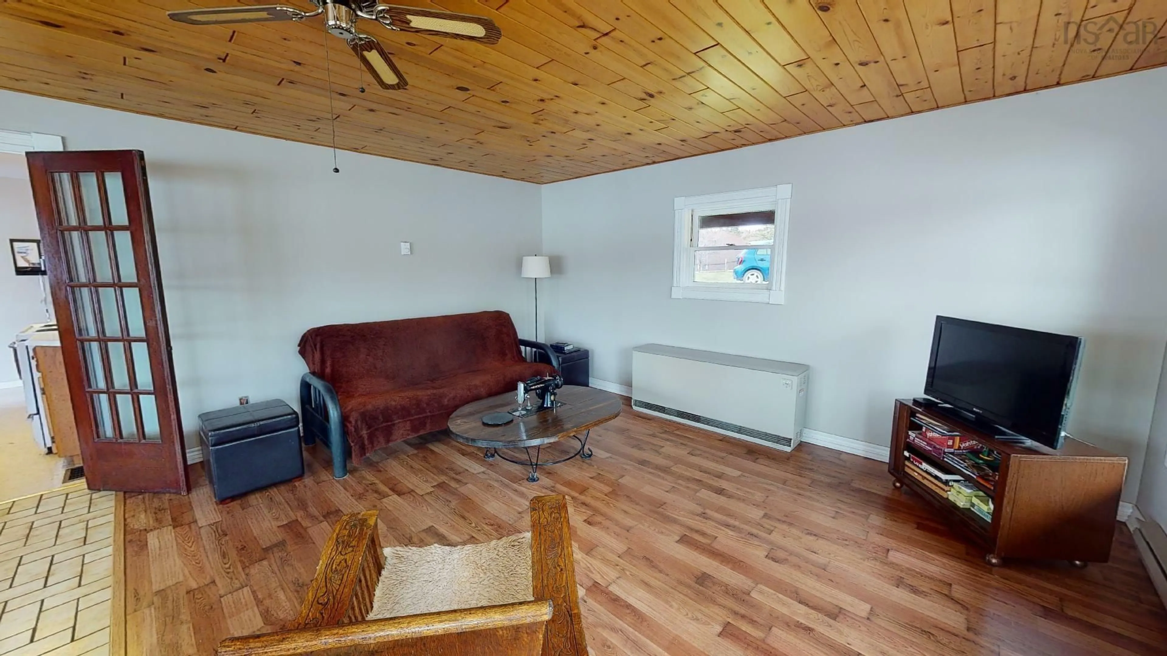 Living room with furniture, wood/laminate floor for 13249 Nova Scotia 7 Hwy, Aspen Nova Scotia B0H 1E0