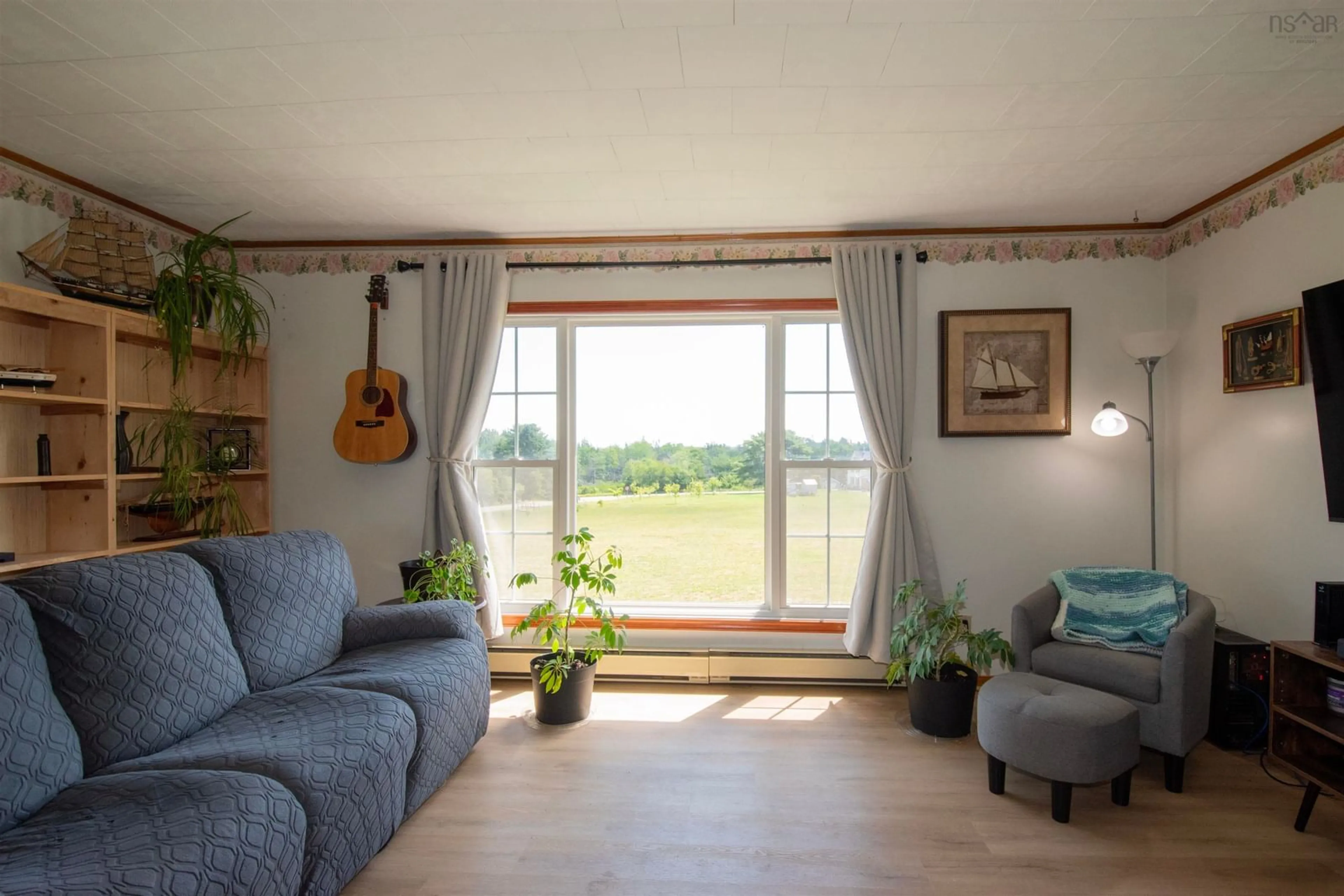 Living room with furniture, wood/laminate floor for 27 Chemin De La Bloquine, Amiraults Hill Nova Scotia B0W 3M0