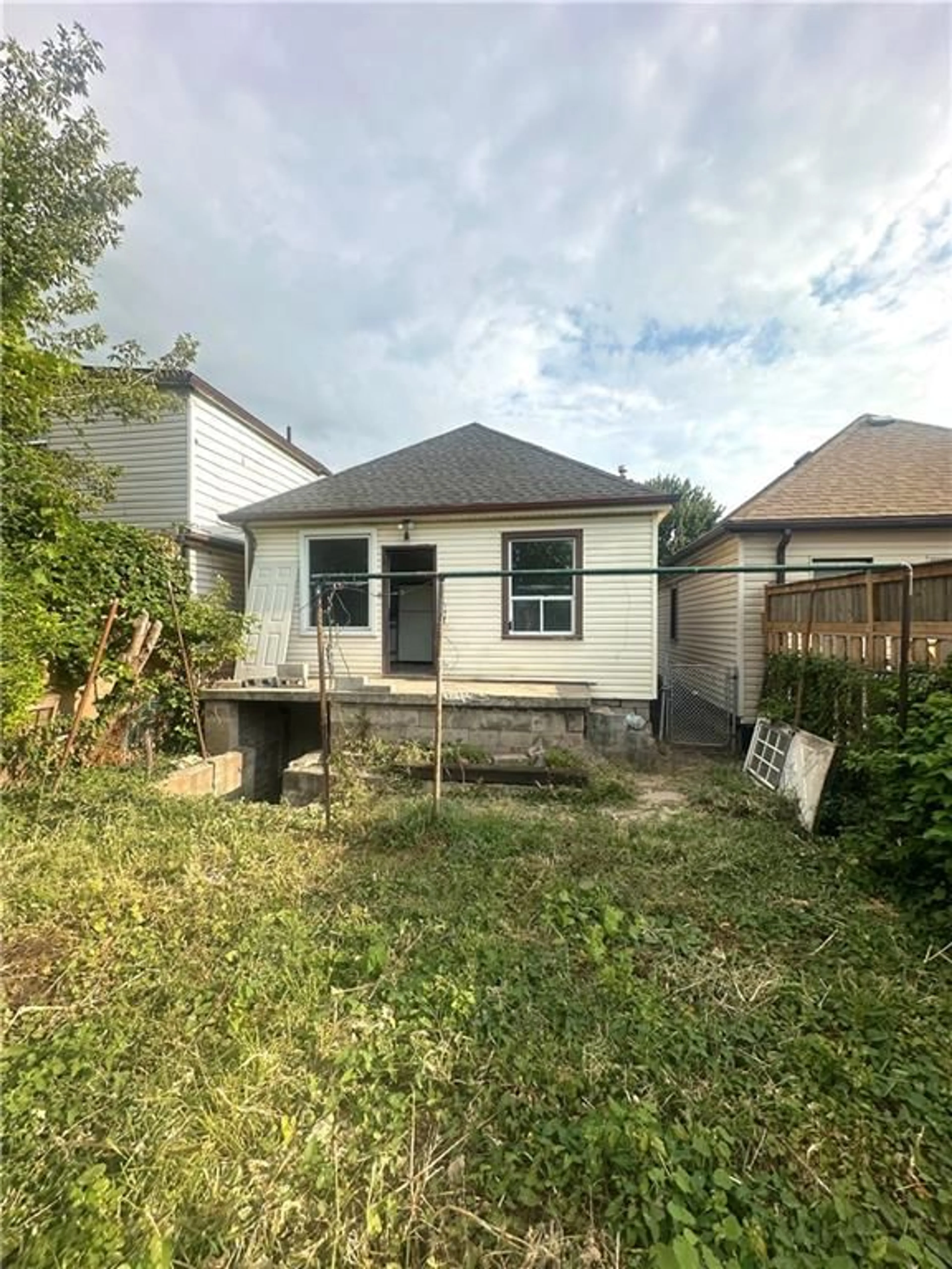 Frontside or backside of a home, the fenced backyard for 1350 CANNON St, Hamilton Ontario L8H 1V8