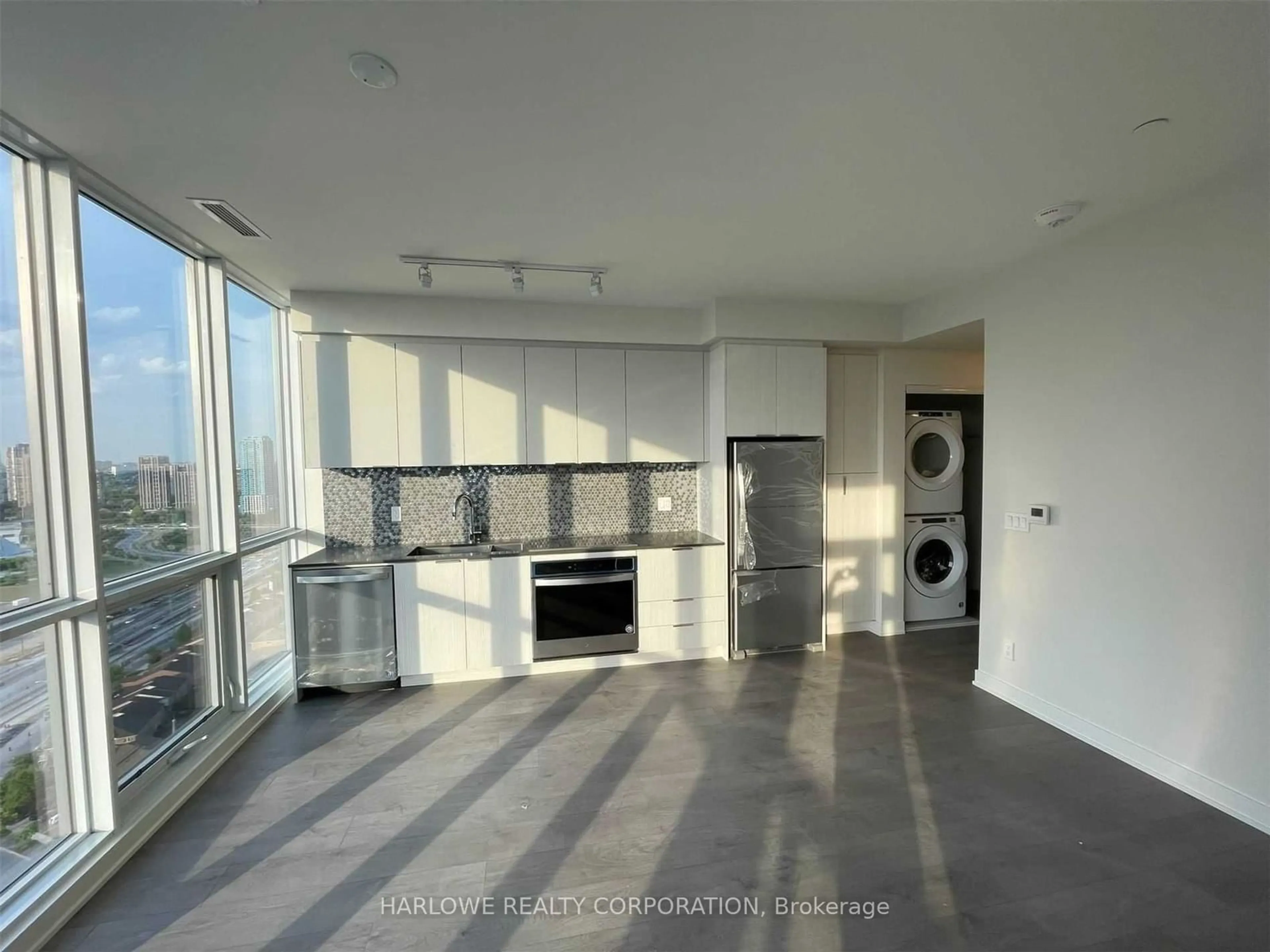 Kitchen with laundary machines, cement floor for 2 Sonic Way #PH02, Toronto Ontario M3C 0P2