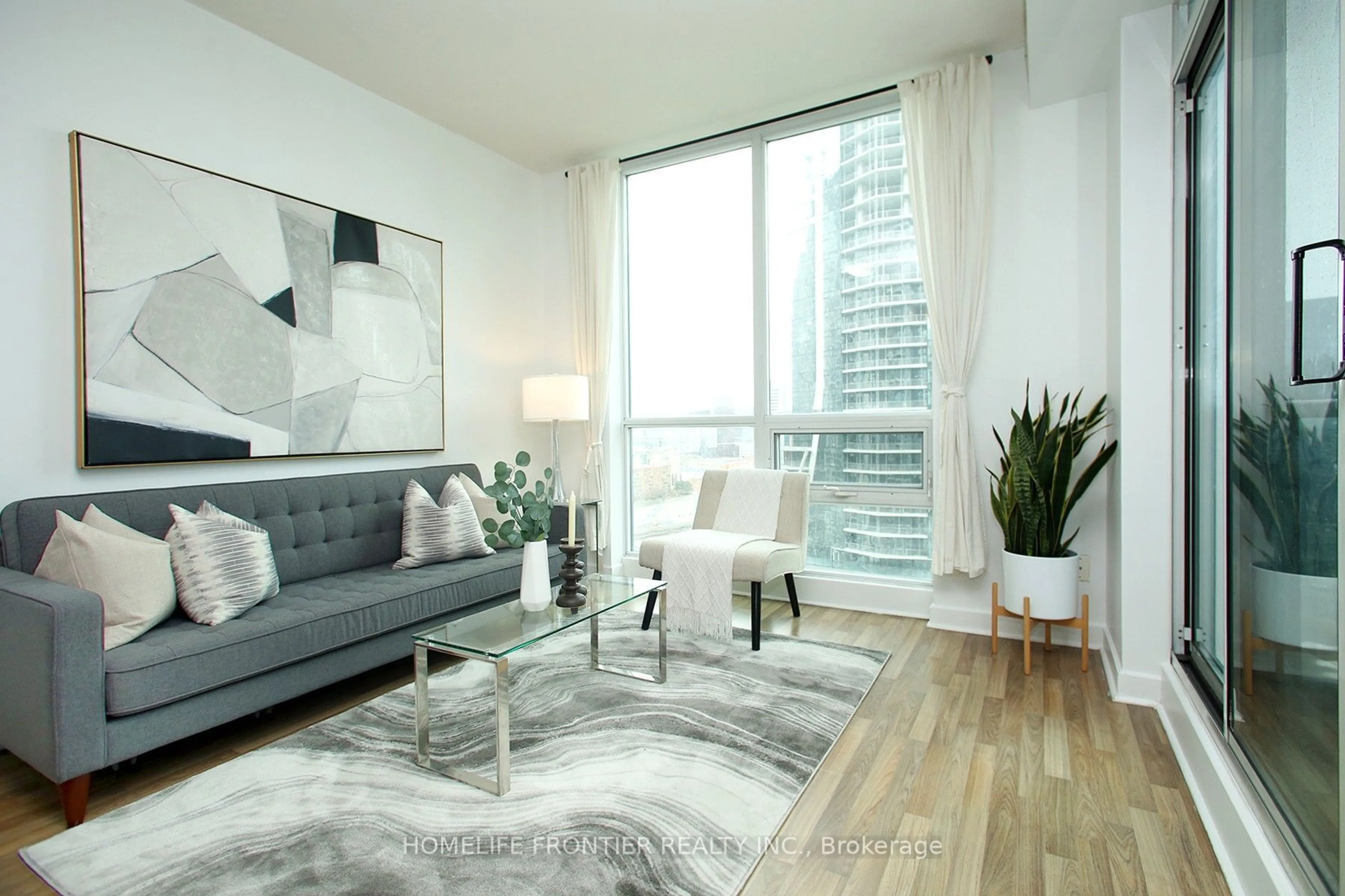 Living room with furniture, wood/laminate floor for 12 Yonge St #2403, Toronto Ontario M5E 1Z9