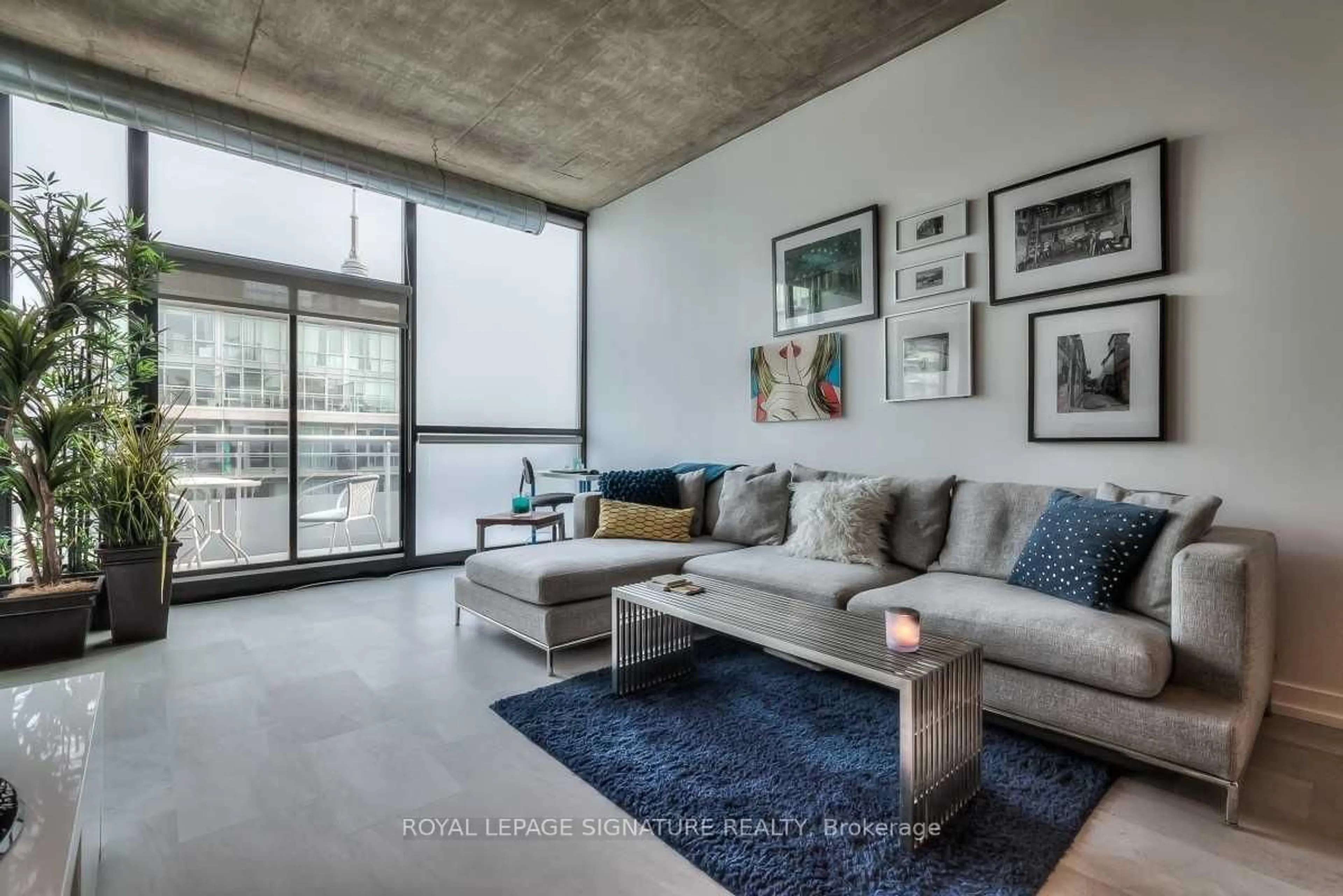 Living room with furniture, cement floor for 60 Bathurst St #909, Toronto Ontario M5V 2P4