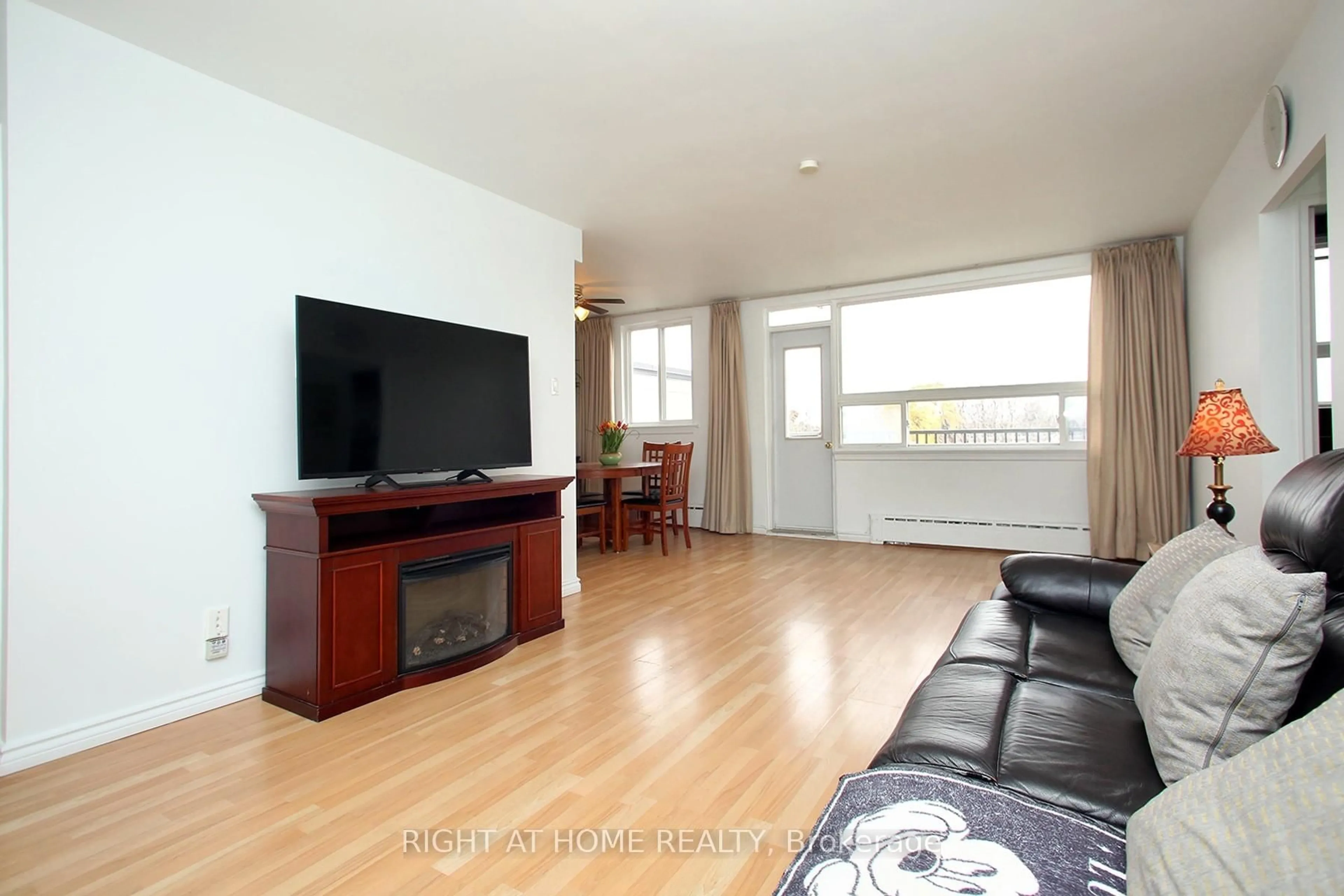 Living room with furniture, wood/laminate floor for 59 Neptune Dr #301, Toronto Ontario M6A 1X2