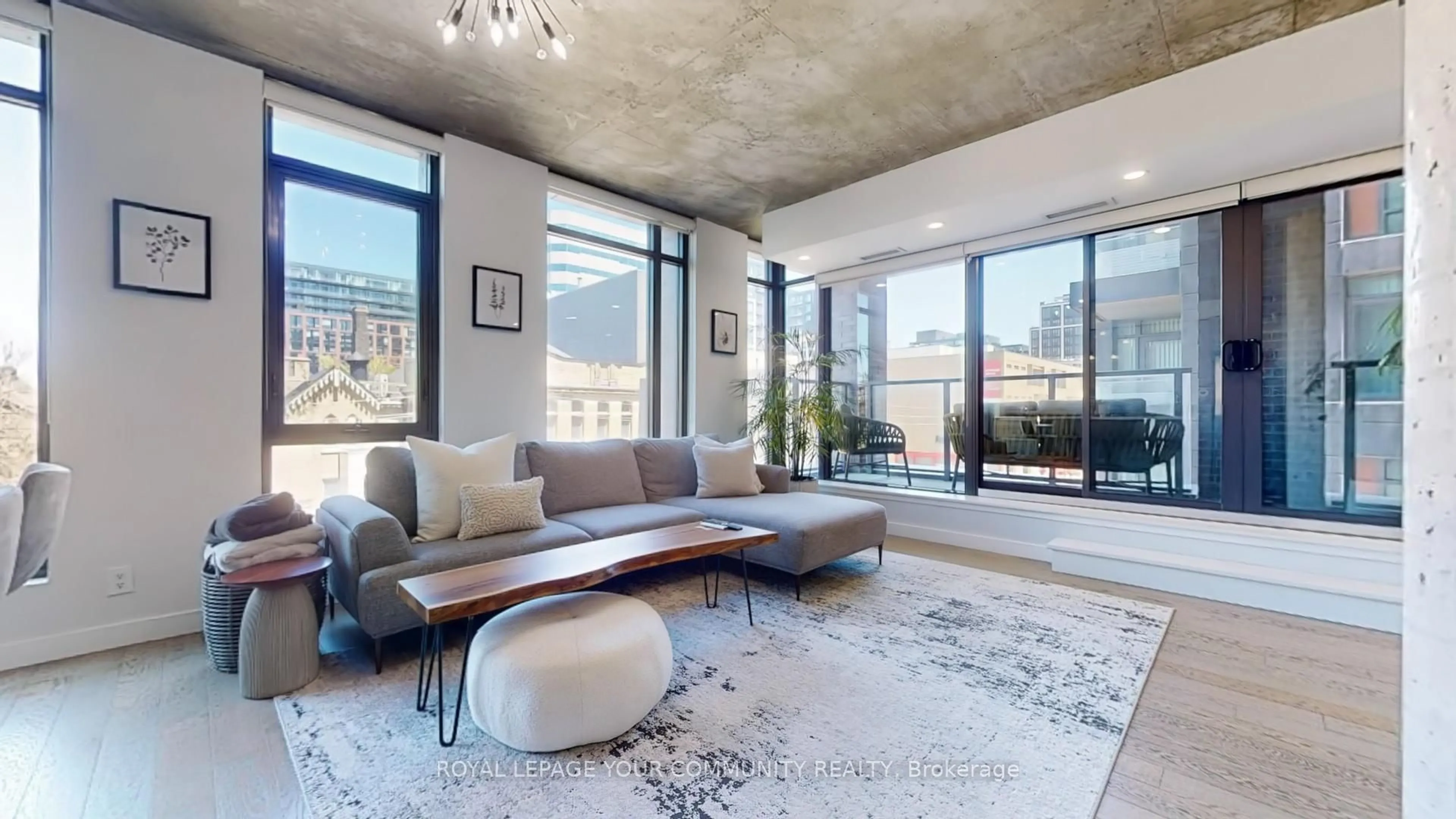 Living room with furniture, cement floor for 111 Bathurst St #314, Toronto Ontario M5V 0M9