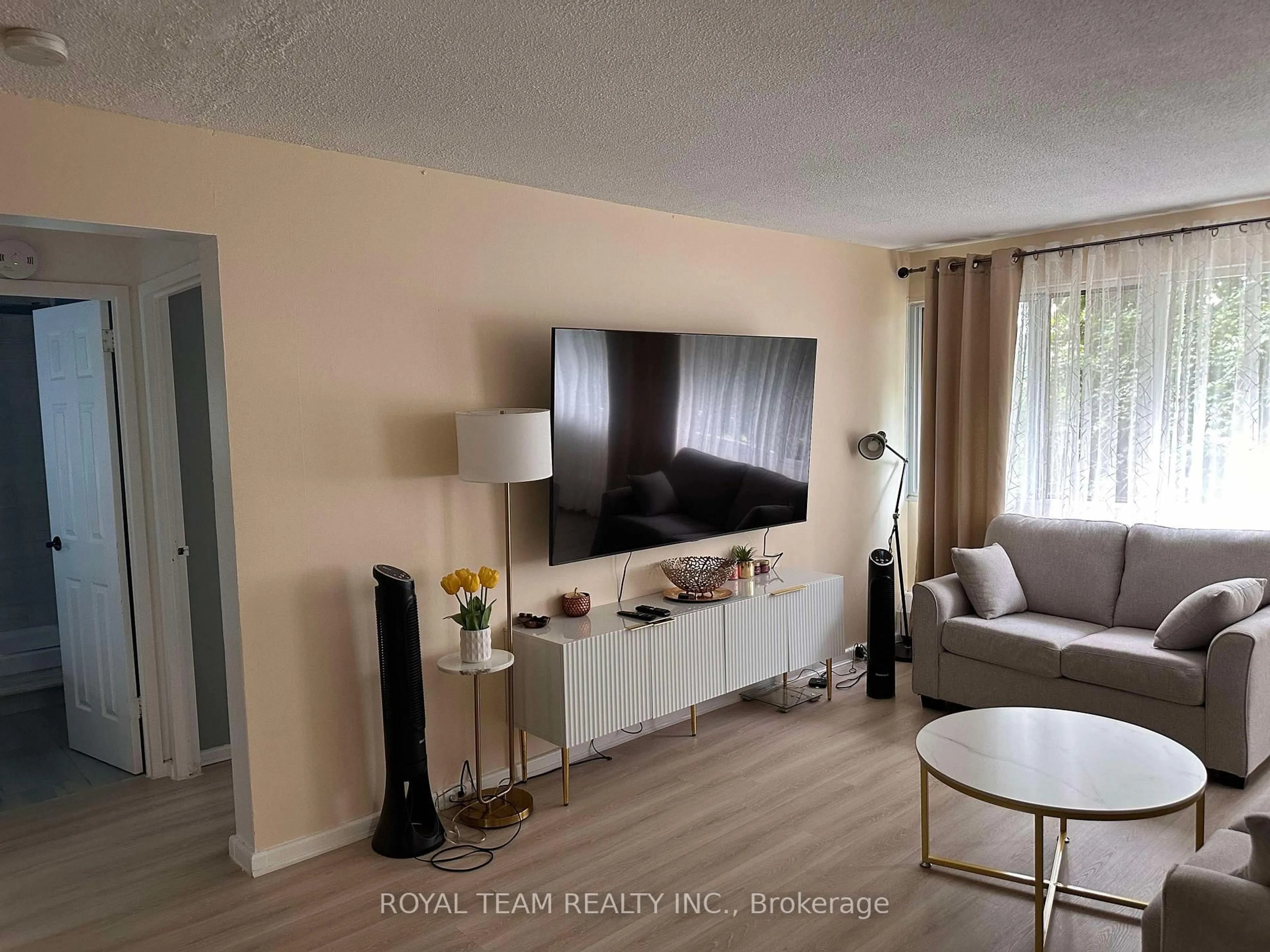 Living room with furniture, wood/laminate floor for 735 Don Mills Rd #201, Toronto Ontario M3C 1S9