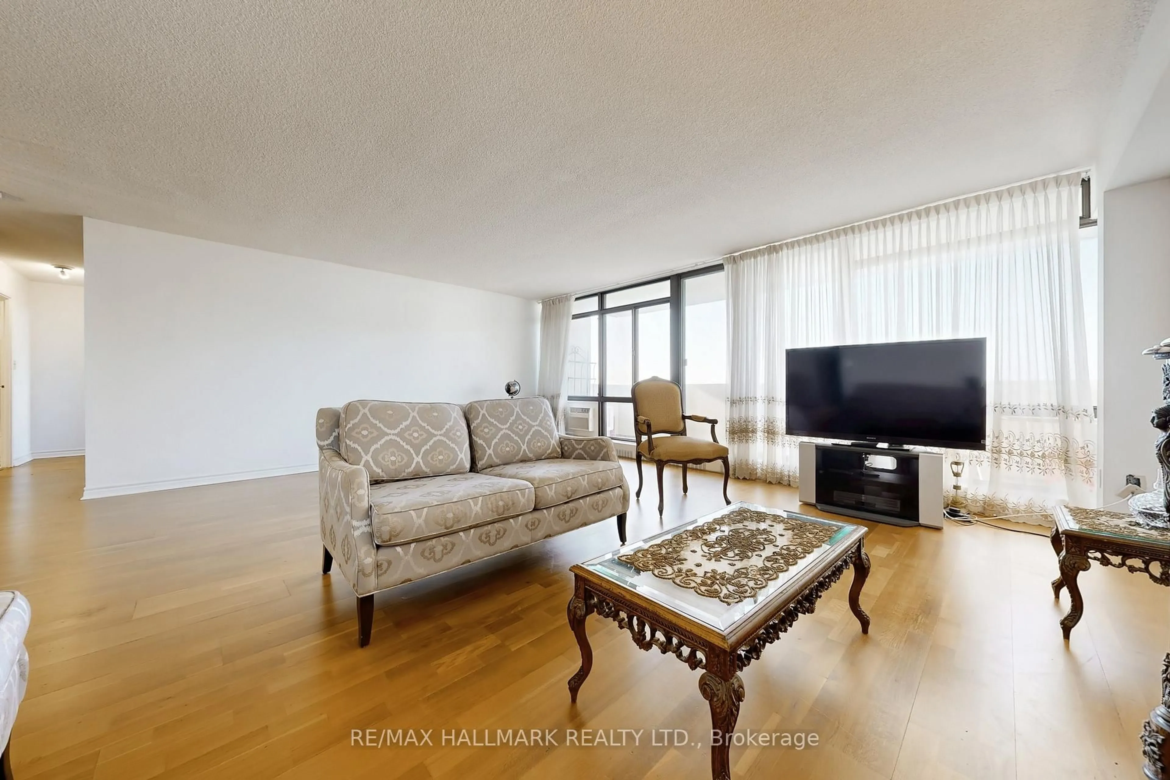 Living room with furniture, wood/laminate floor for 3300 Don Mills Rd Rd #1802, Toronto Ontario M2J 4X7