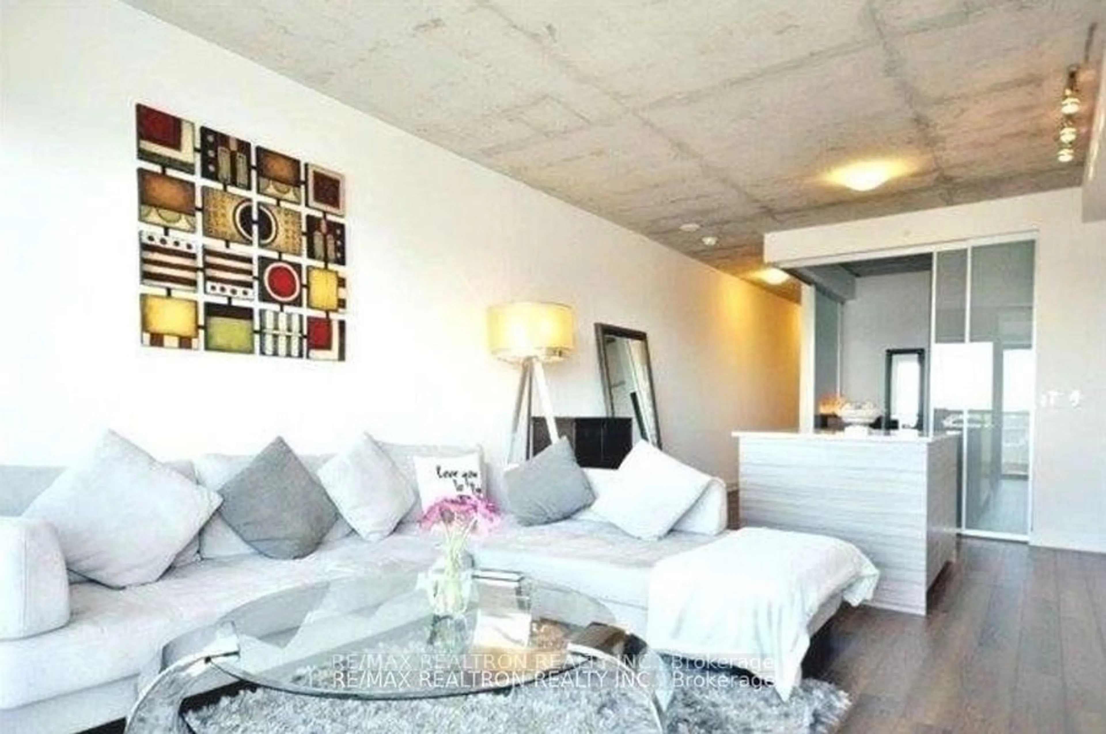 Living room with furniture, cement floor for 210 Simcoe St #1604, Toronto Ontario M5T 0A9