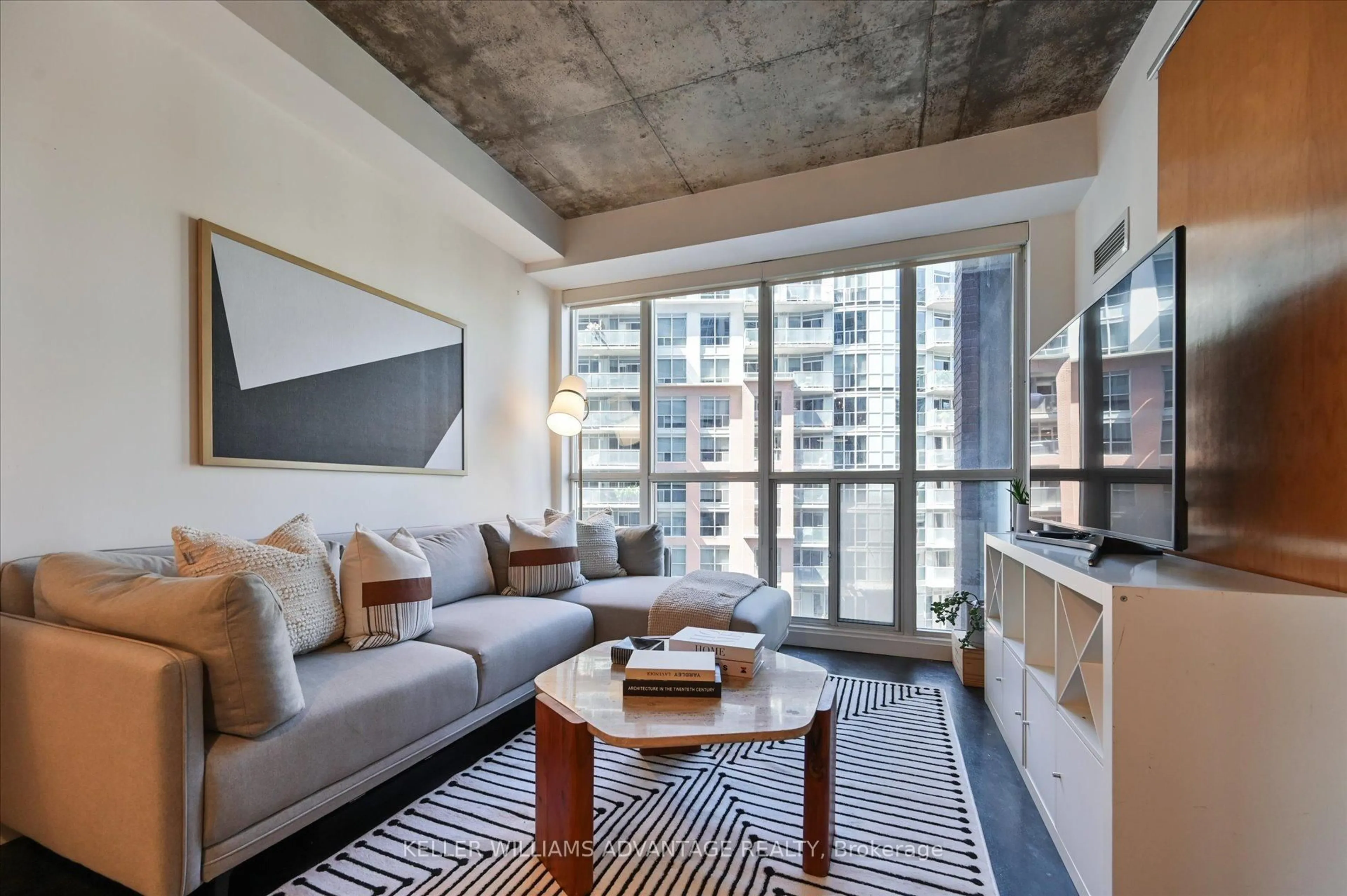 Living room with furniture, cement floor for 1 Shaw St #402, Toronto Ontario M6K 0A1