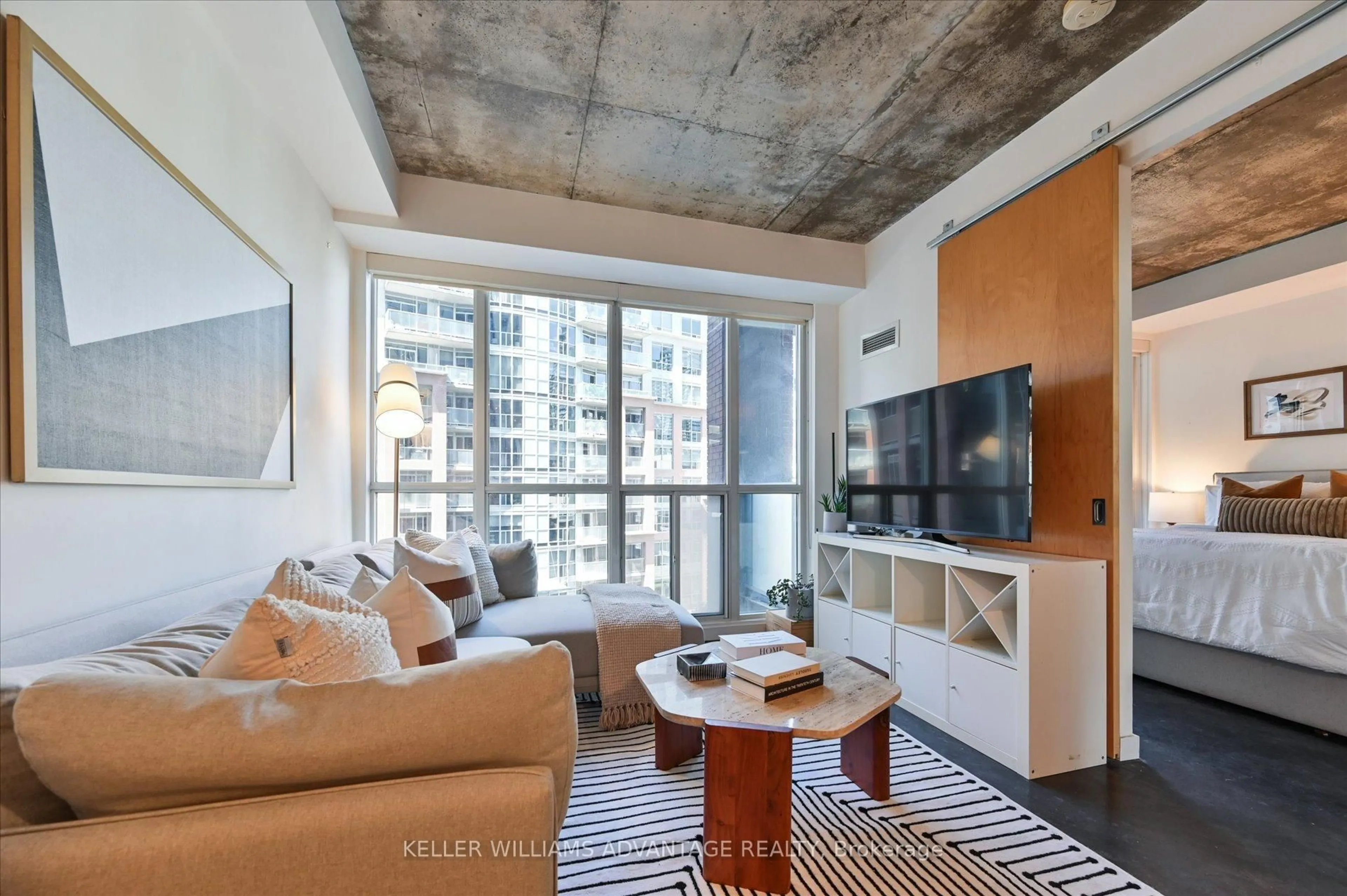 Living room with furniture, cement floor for 1 Shaw St #402, Toronto Ontario M6K 0A1