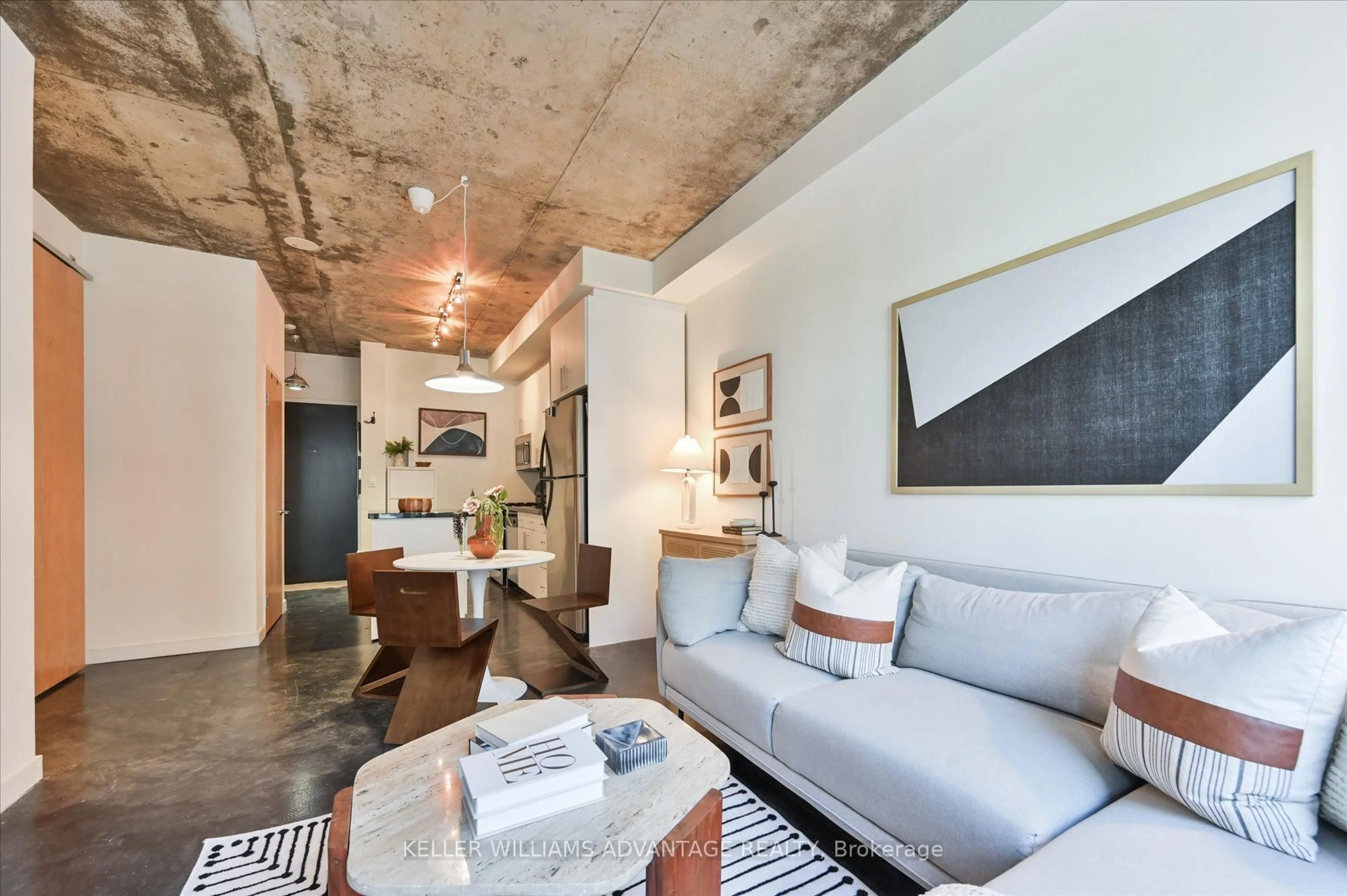 Living room with furniture, cement floor for 1 Shaw St #402, Toronto Ontario M6K 0A1