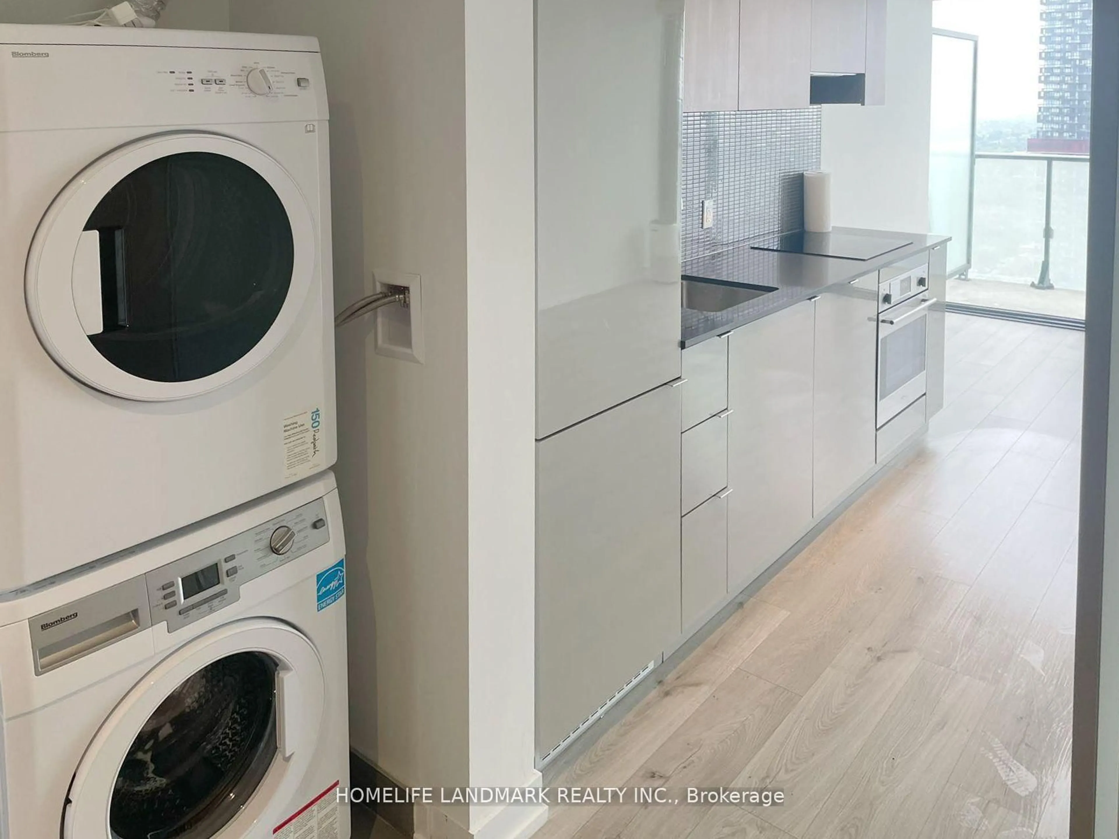 Kitchen with laundary machines, wood/laminate floor for 161 Roehampton Ave #3901, Toronto Ontario M4P 1P9