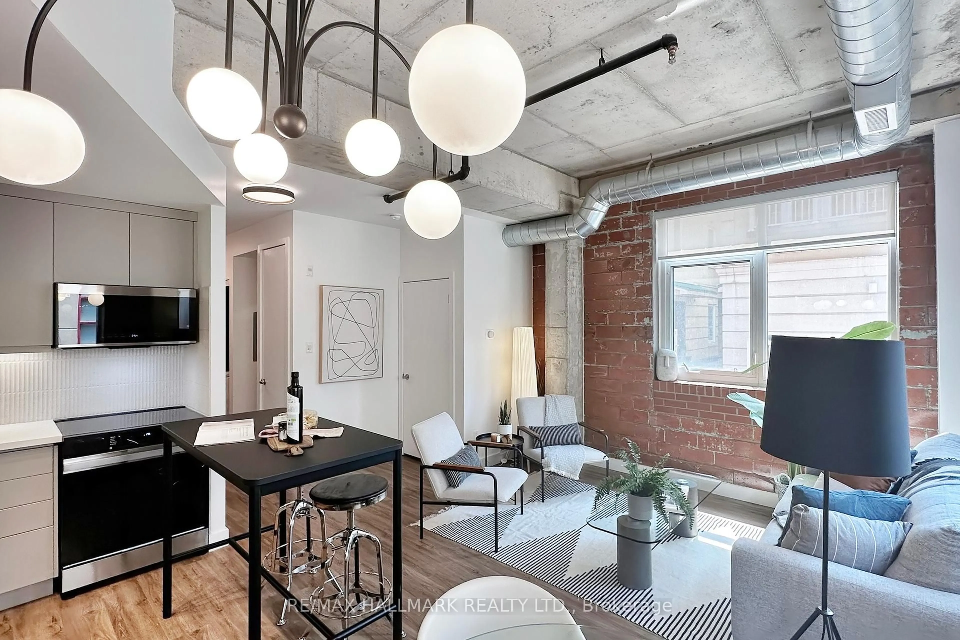 Living room with furniture, cement floor for 10 Wellesley Pl #206, Toronto Ontario M4Y 1B1