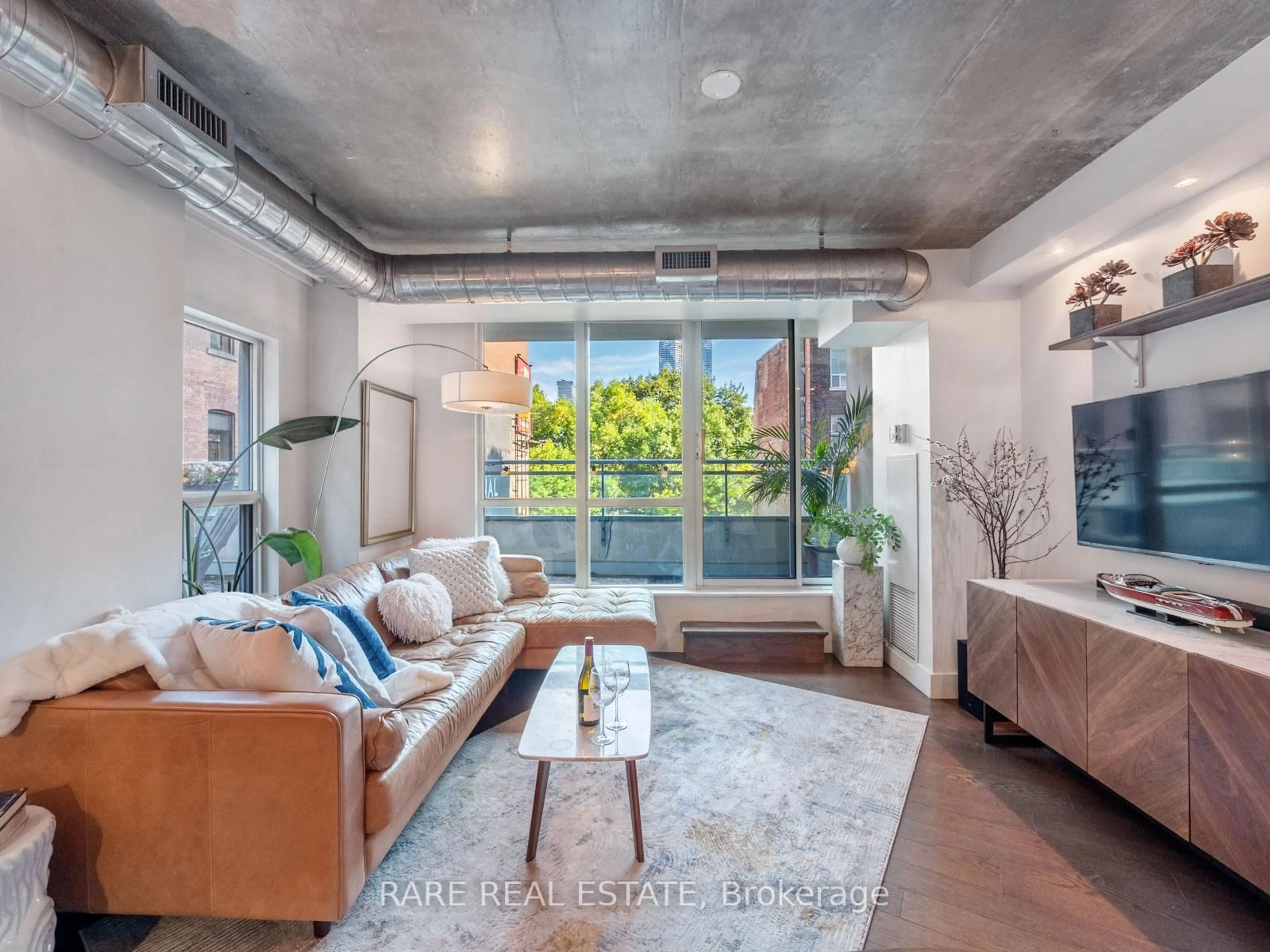 Living room with furniture, cement floor for 77 Lombard St #202, Toronto Ontario M5C 3E1