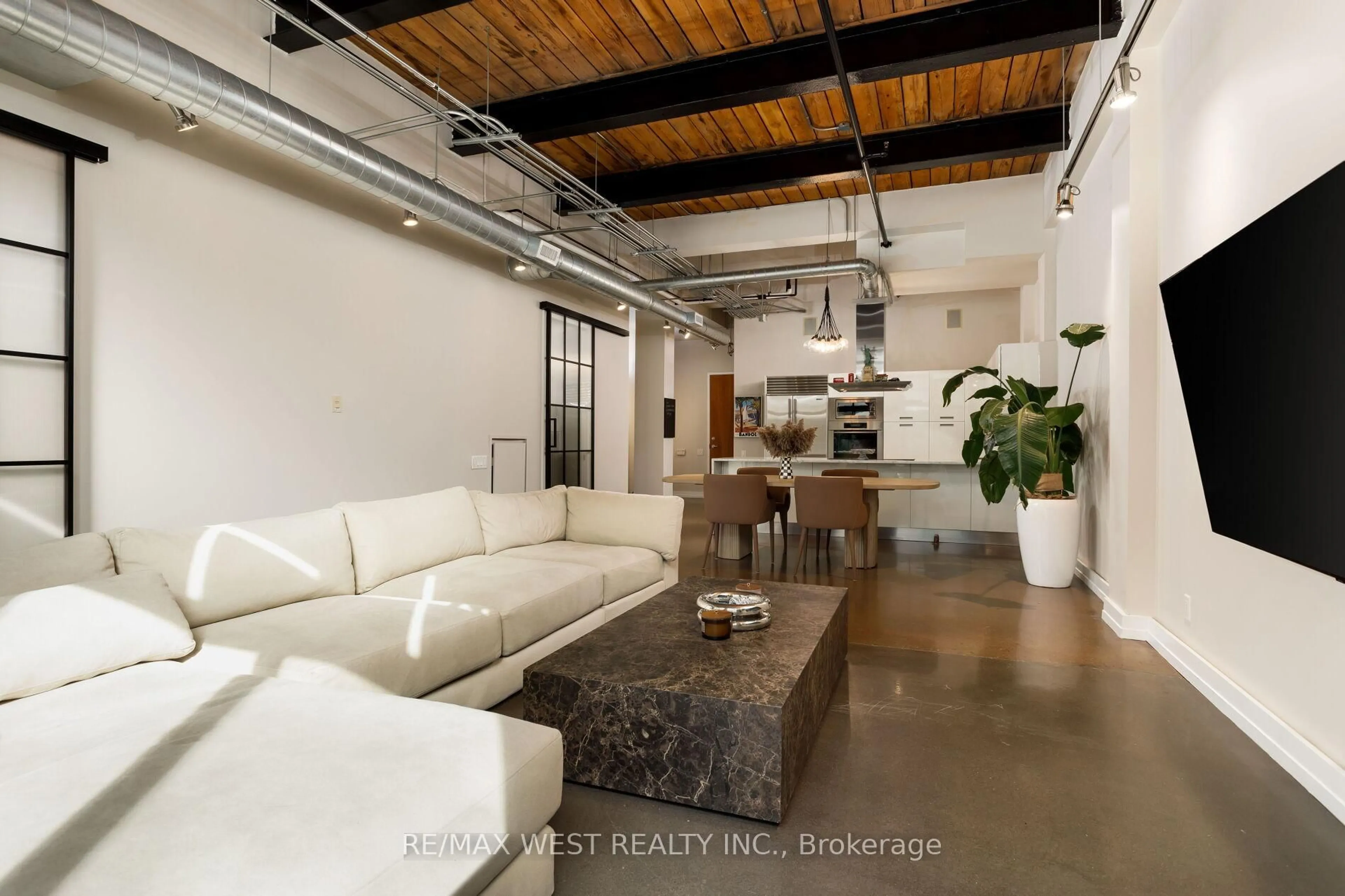 Living room with furniture, cement floor for 43 Hanna Ave #115, Toronto Ontario M6K 1X1