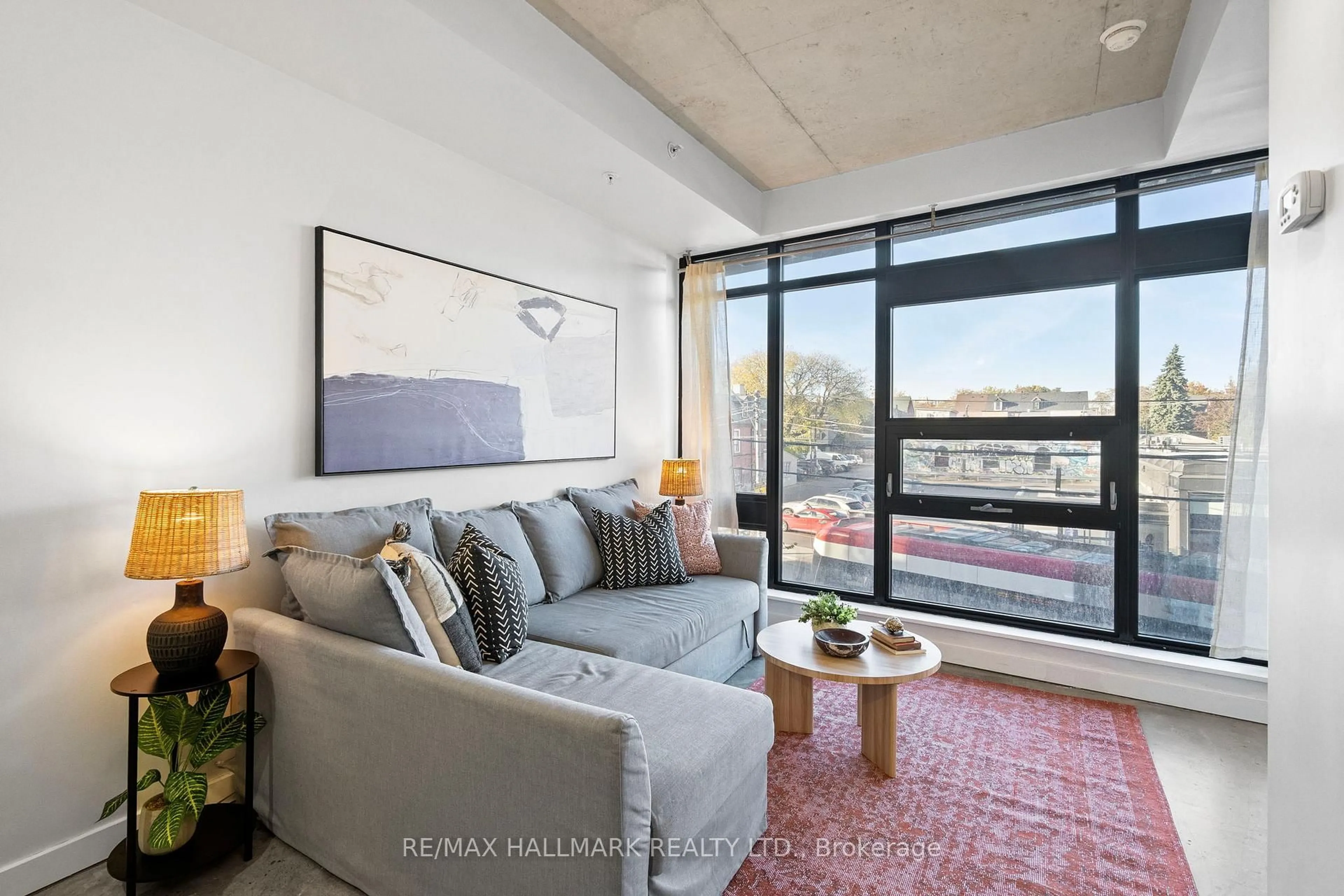 Living room with furniture, cement floor for 1239 Dundas St #207, Toronto Ontario M6J 1X6