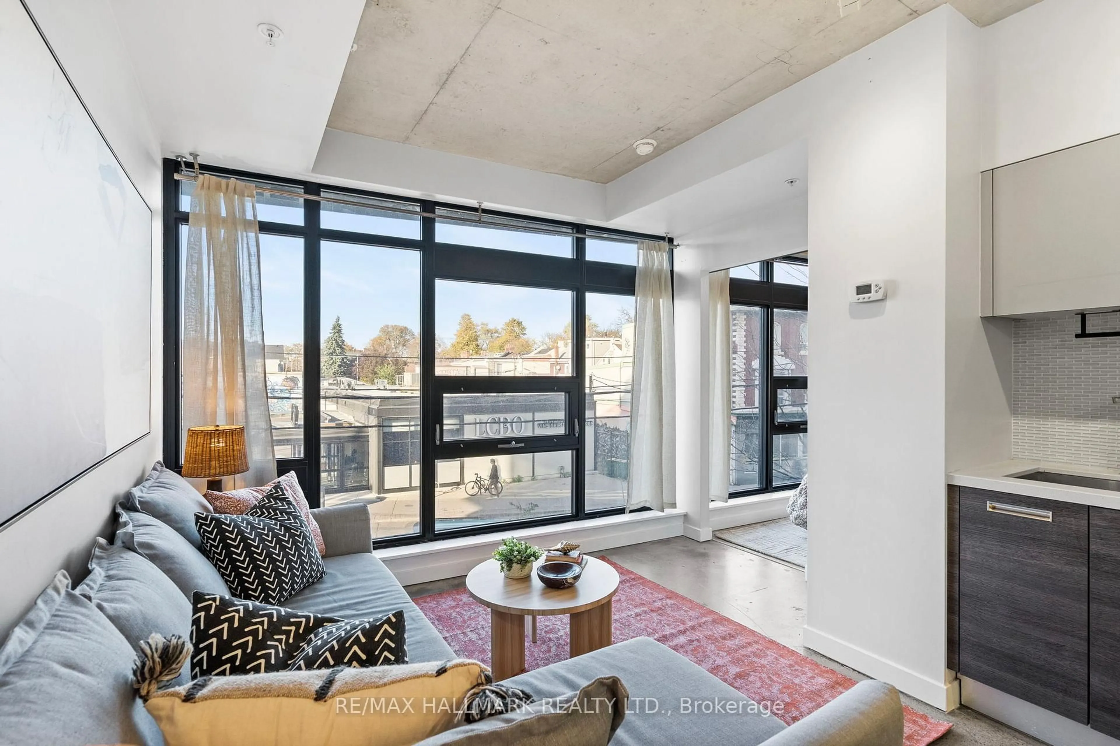 Living room with furniture, cement floor for 1239 Dundas St #207, Toronto Ontario M6J 1X6