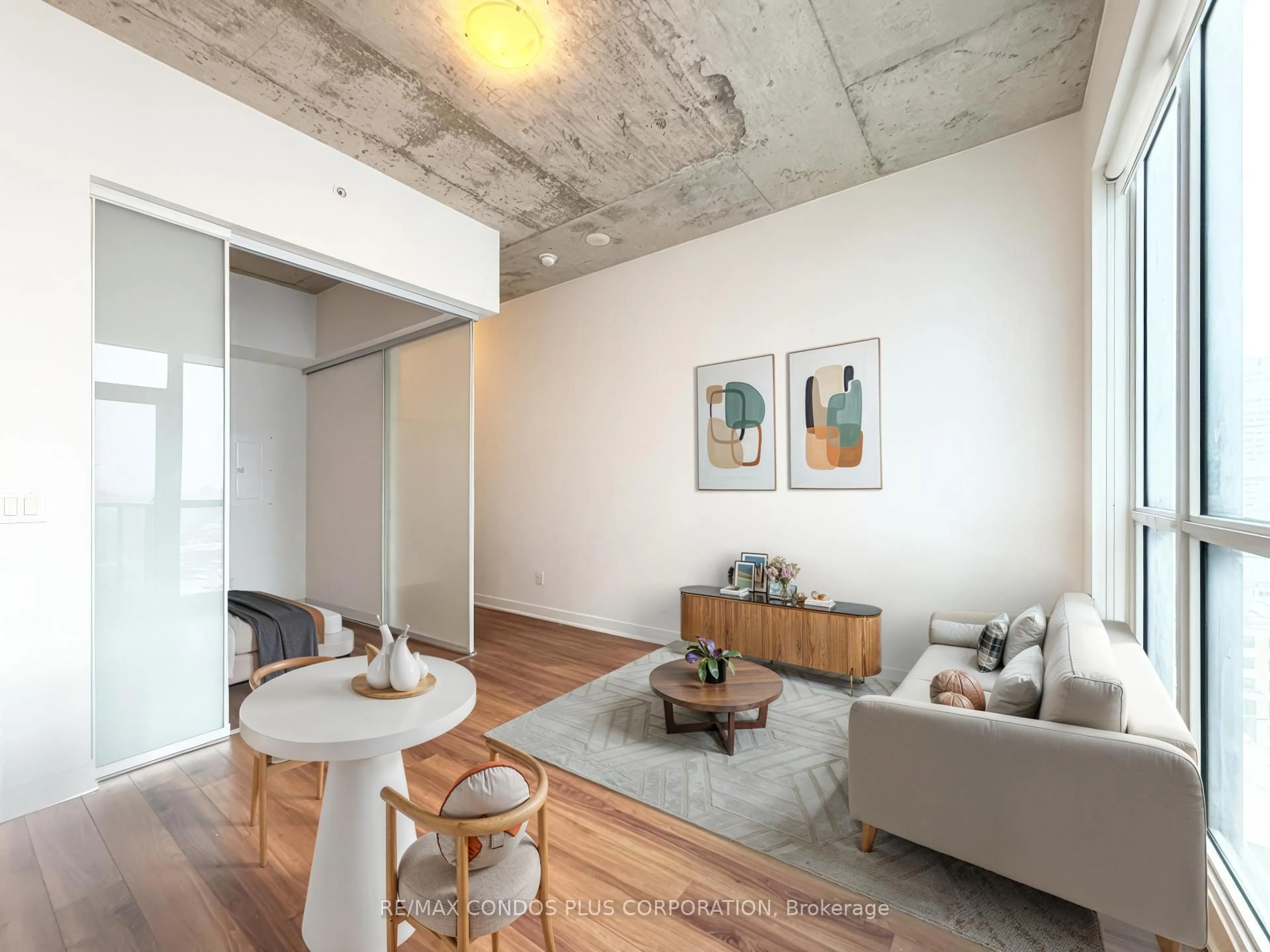 Living room with furniture, cement floor for 210 Simcoe St #2410, Toronto Ontario M5T 0A9