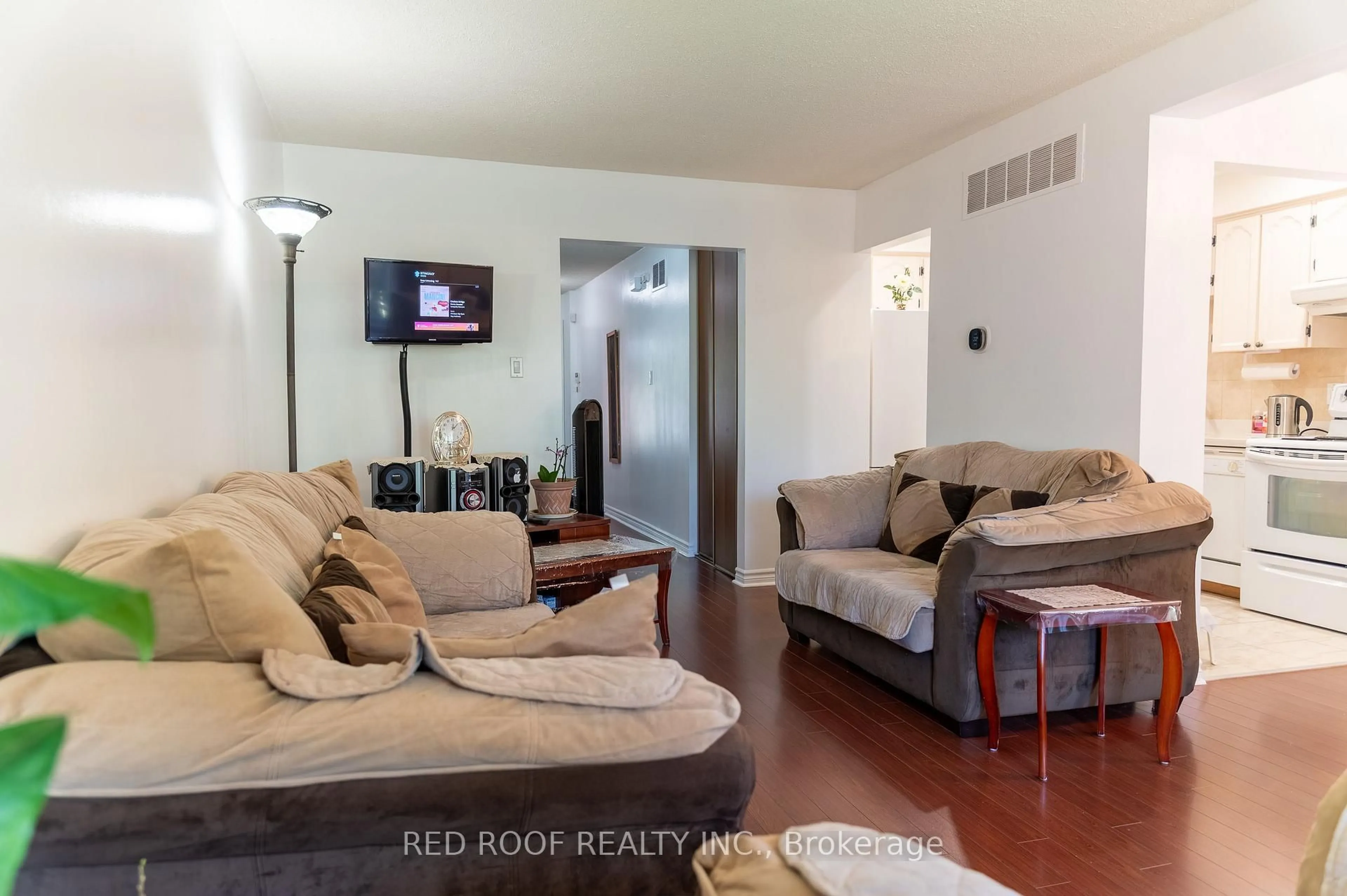 Living room with furniture, wood/laminate floor for 64 Farm Green Way #64, Toronto Ontario M3A 3M2