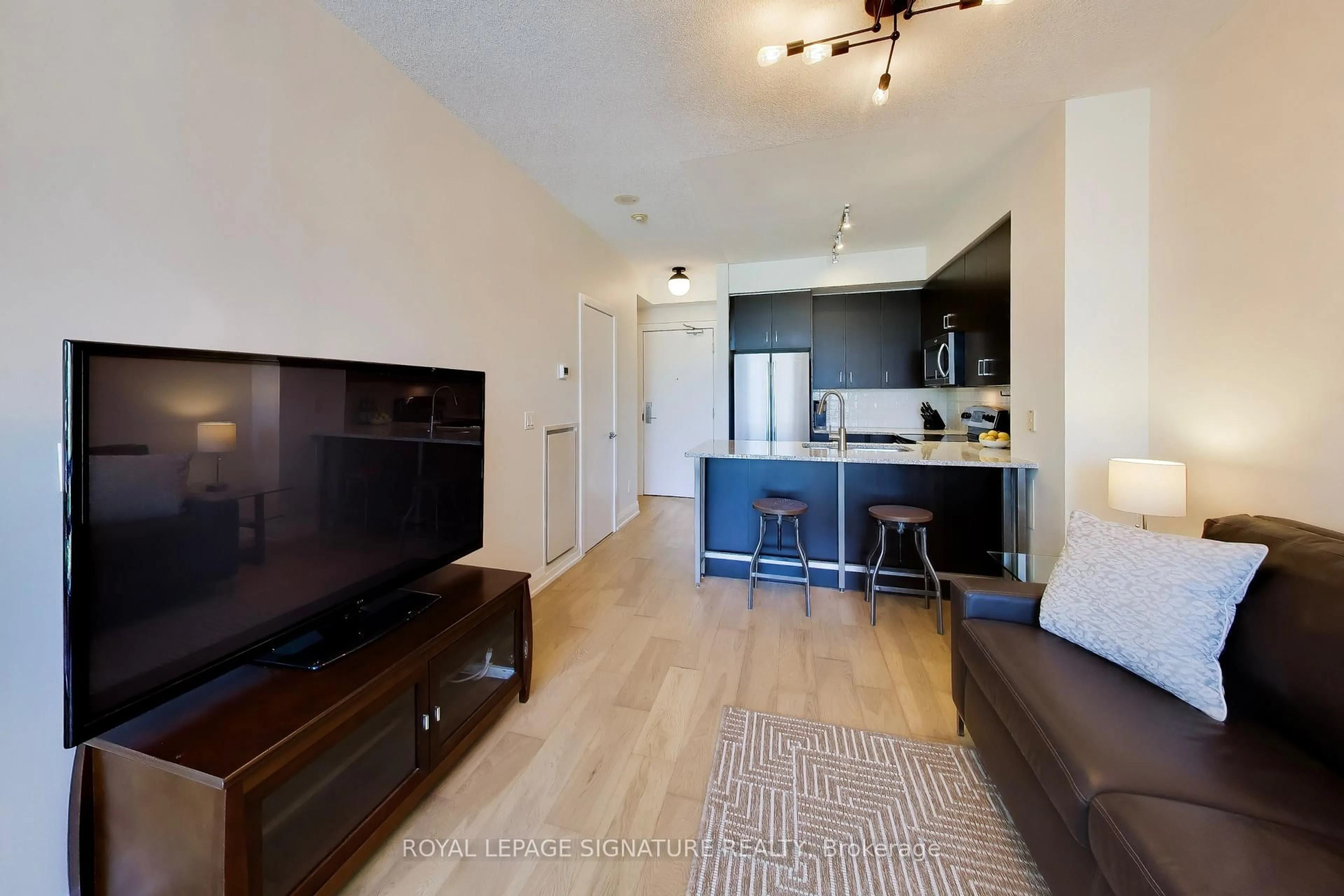 Living room with furniture, wood/laminate floor for 438 King St #1219, Toronto Ontario M5V 3T9