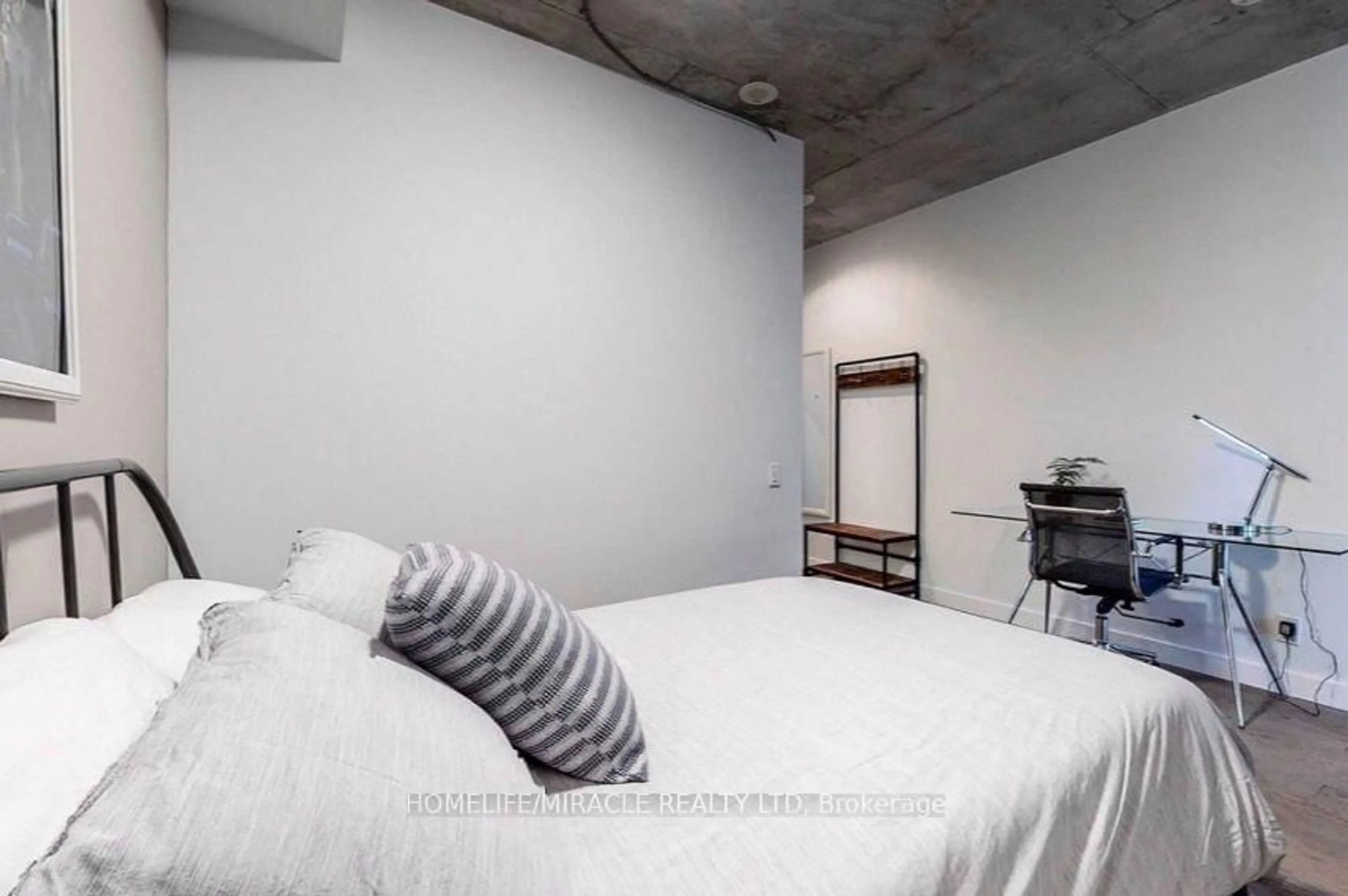 Bedroom with bed, cement floor for 318 King St #207, Toronto Ontario M5A 1C1