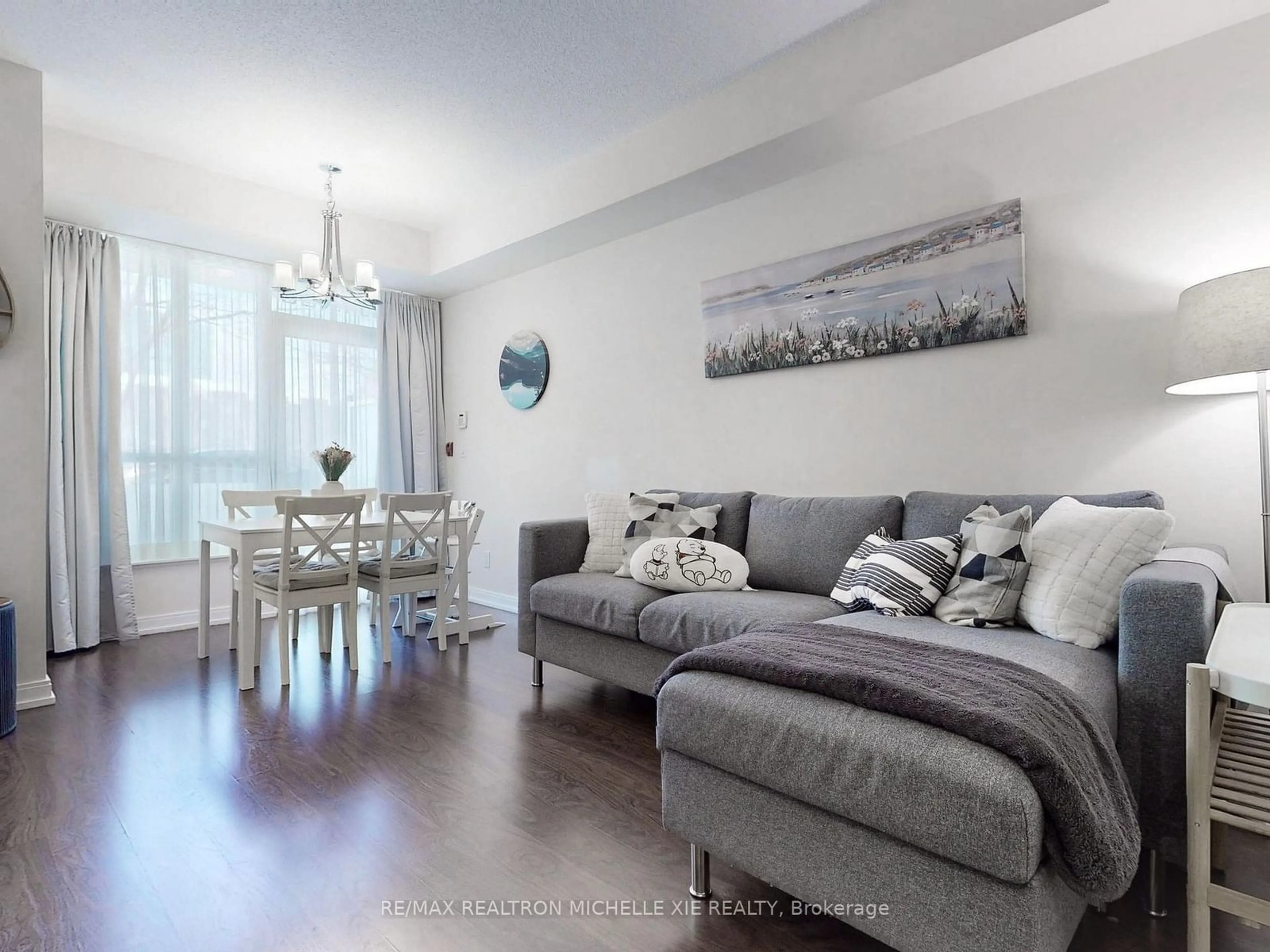 Living room with furniture, wood/laminate floor for 151 Village Green Sq #106, Toronto Ontario M1S 0K5