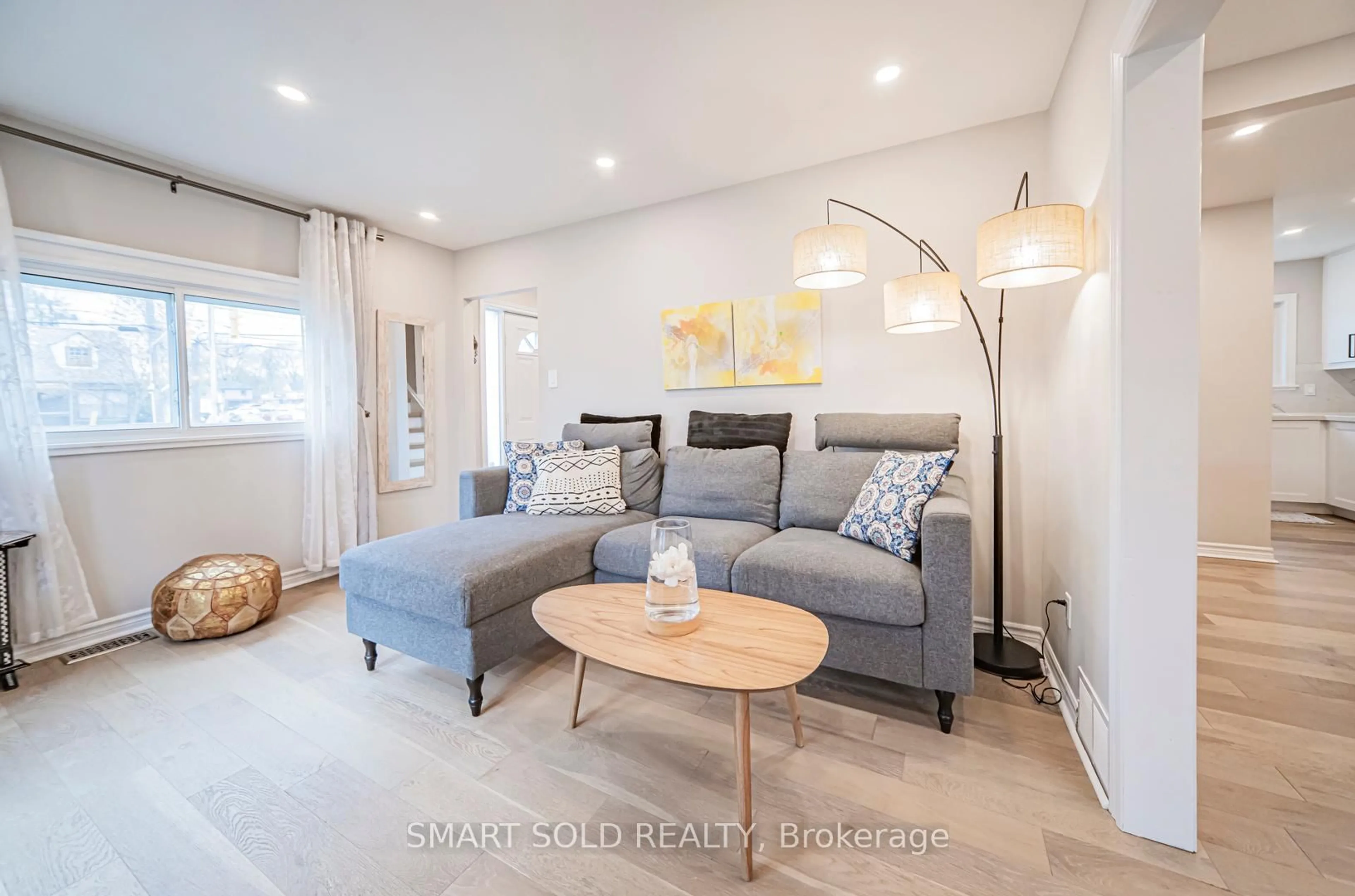 Living room with furniture, wood/laminate floor for 3133 St. Clair Ave, Toronto Ontario M1L 1V2