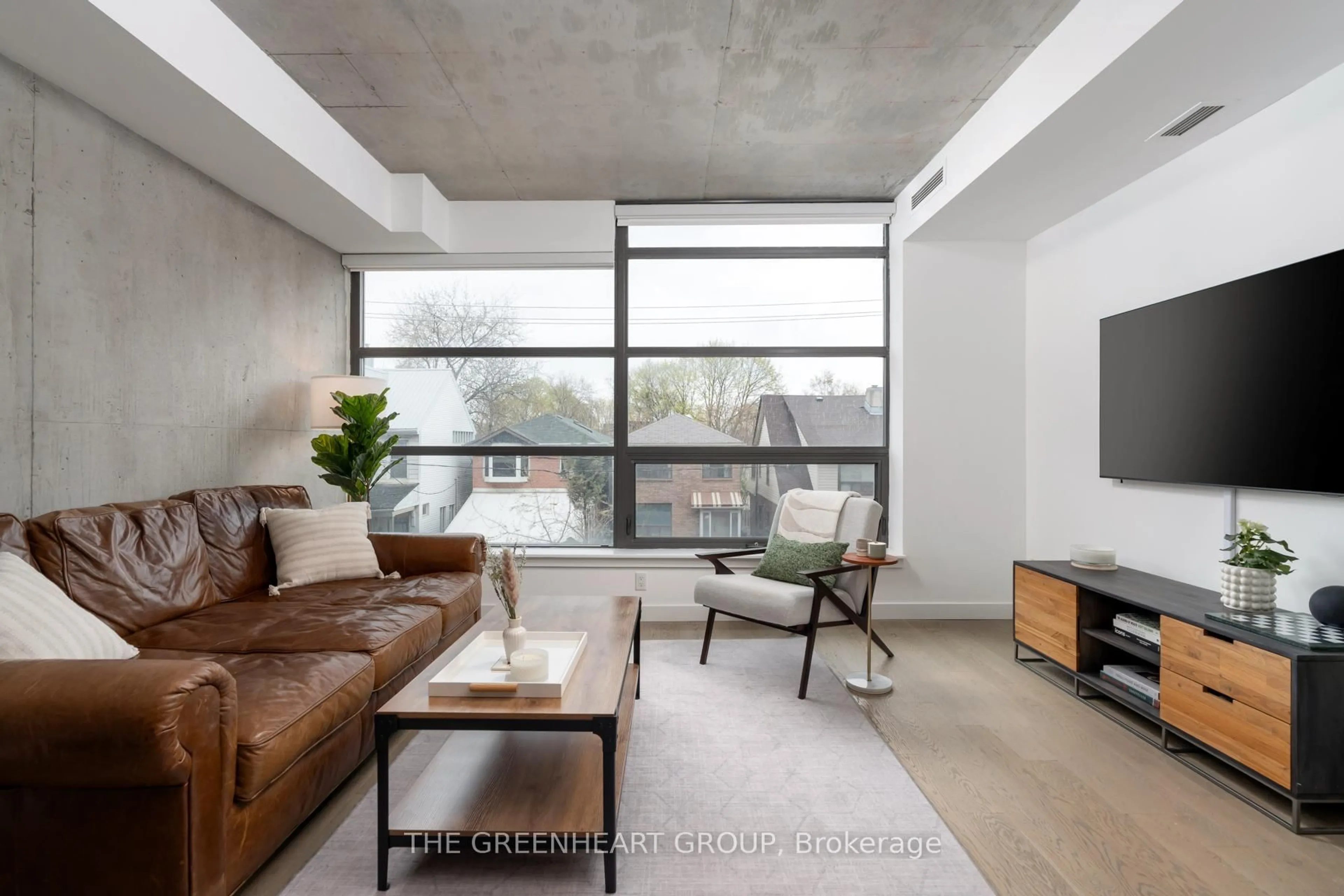 Living room with furniture, cement floor for 90 Broadview Ave #205, Toronto Ontario M4M 0A7