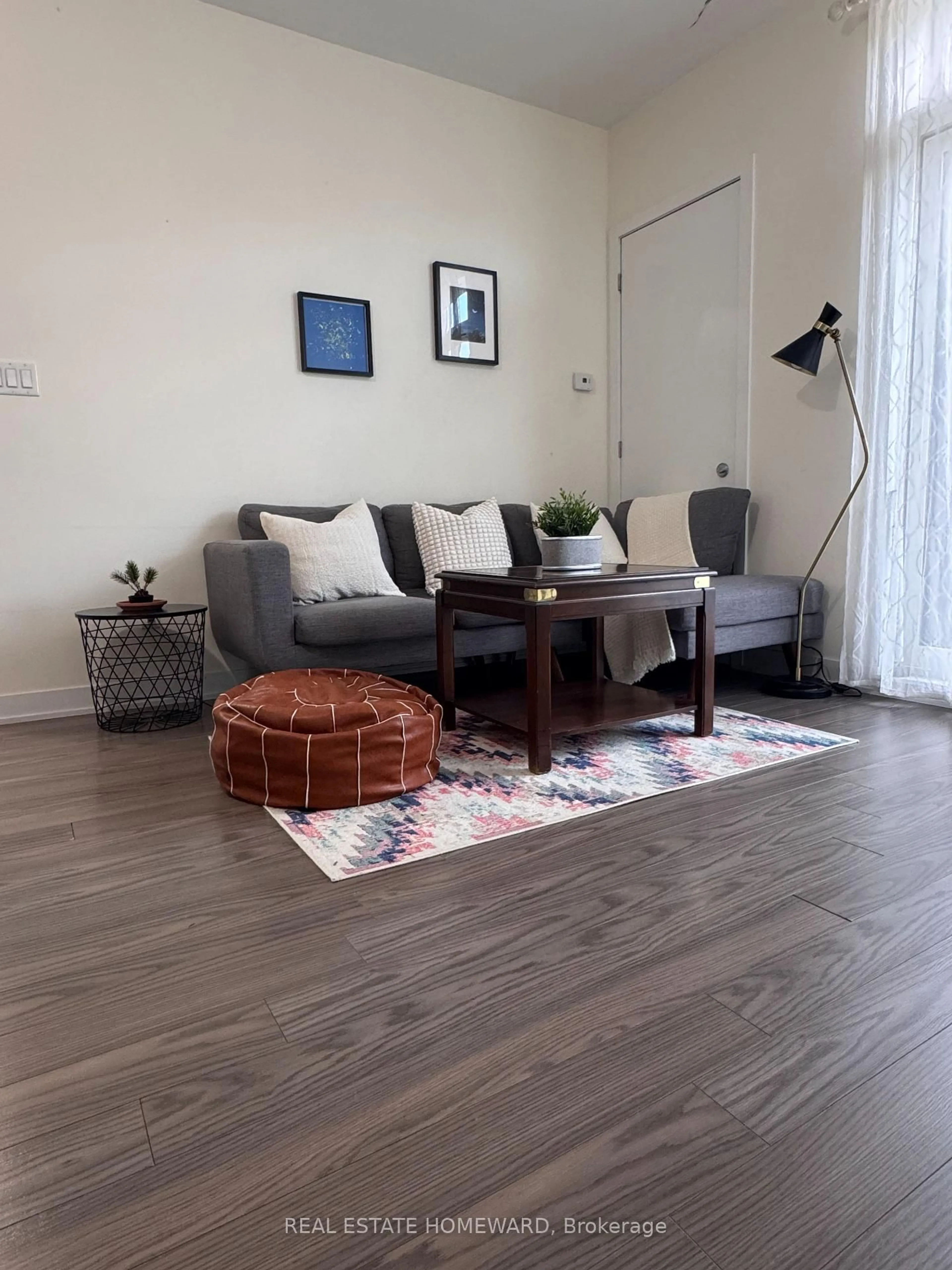 Living room with furniture, wood/laminate floor for 3560 St Clair Ave Ave #106, Toronto Ontario M1K 0A9