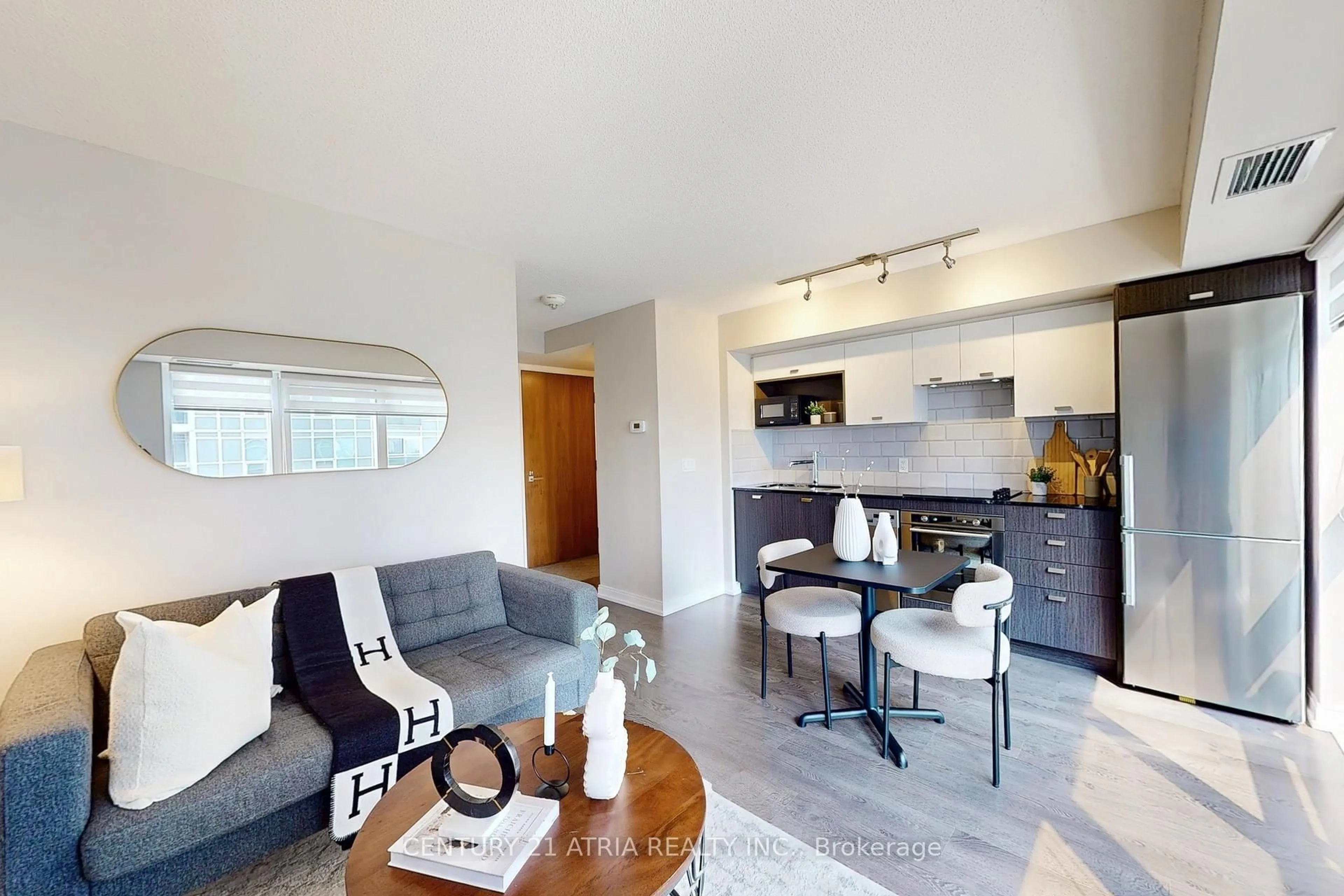 Living room with furniture, wood/laminate floor for 275 Village Green Sq #717, Toronto Ontario M1S 0L8
