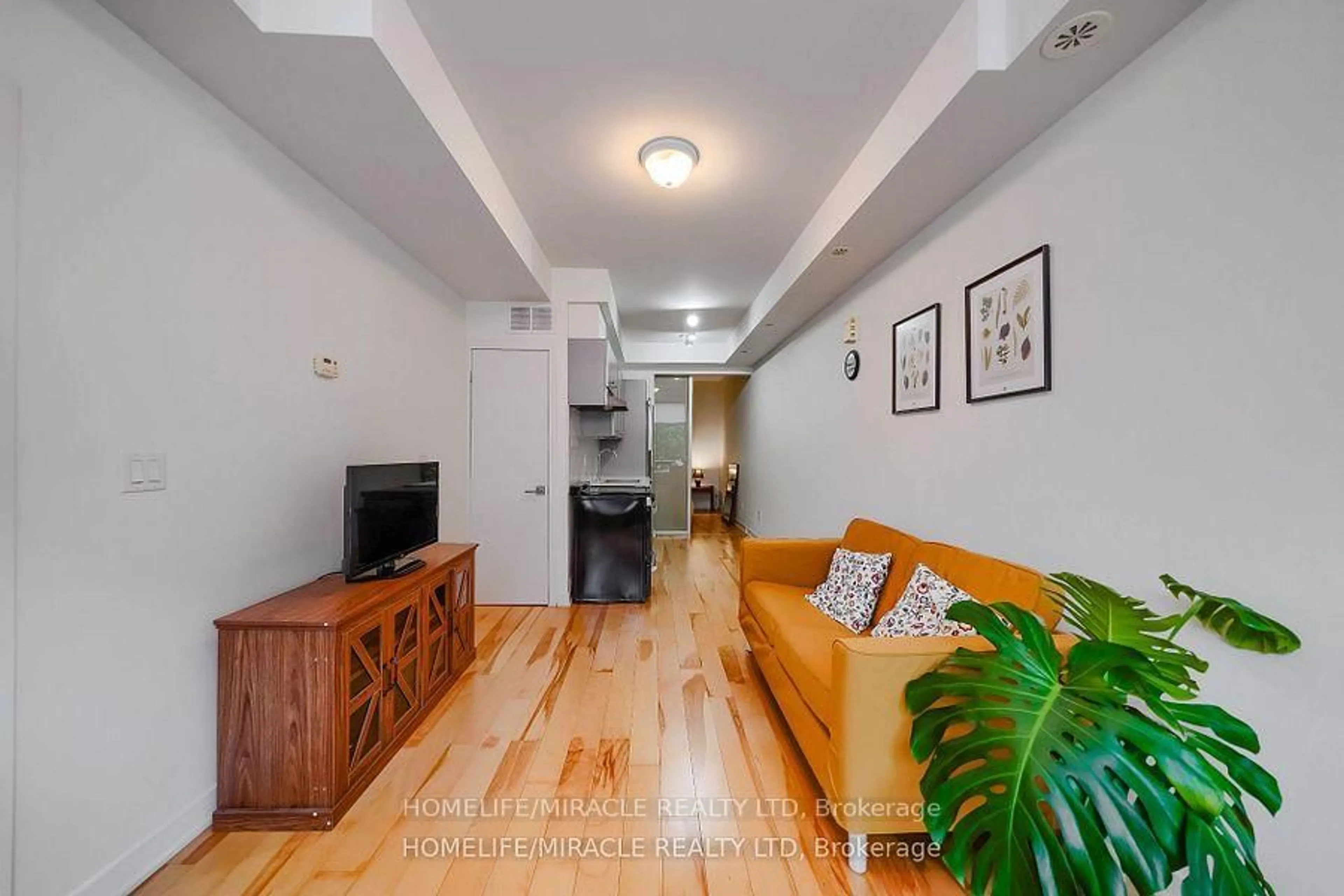 Living room with furniture, wood/laminate floor for 1331 Gerrard St #2, Toronto Ontario M4L 1Y8