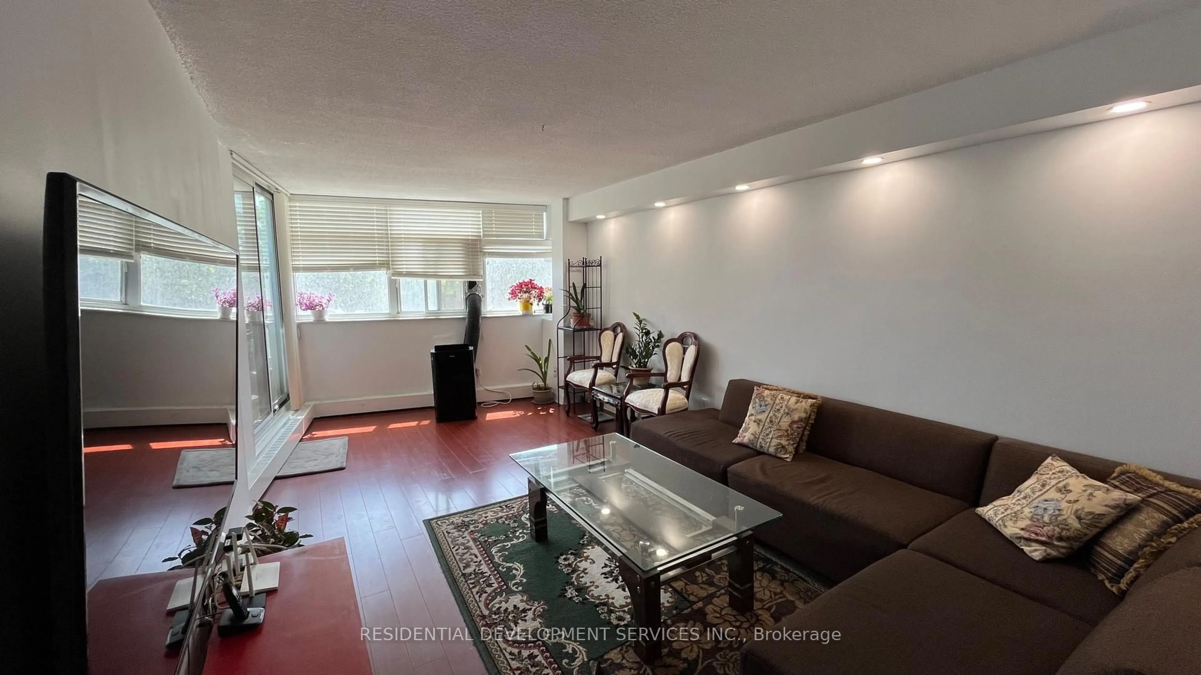 Living room with furniture, wood/laminate floor for 2050 Bridletowne Circ #201, Toronto Ontario M1W 2V5