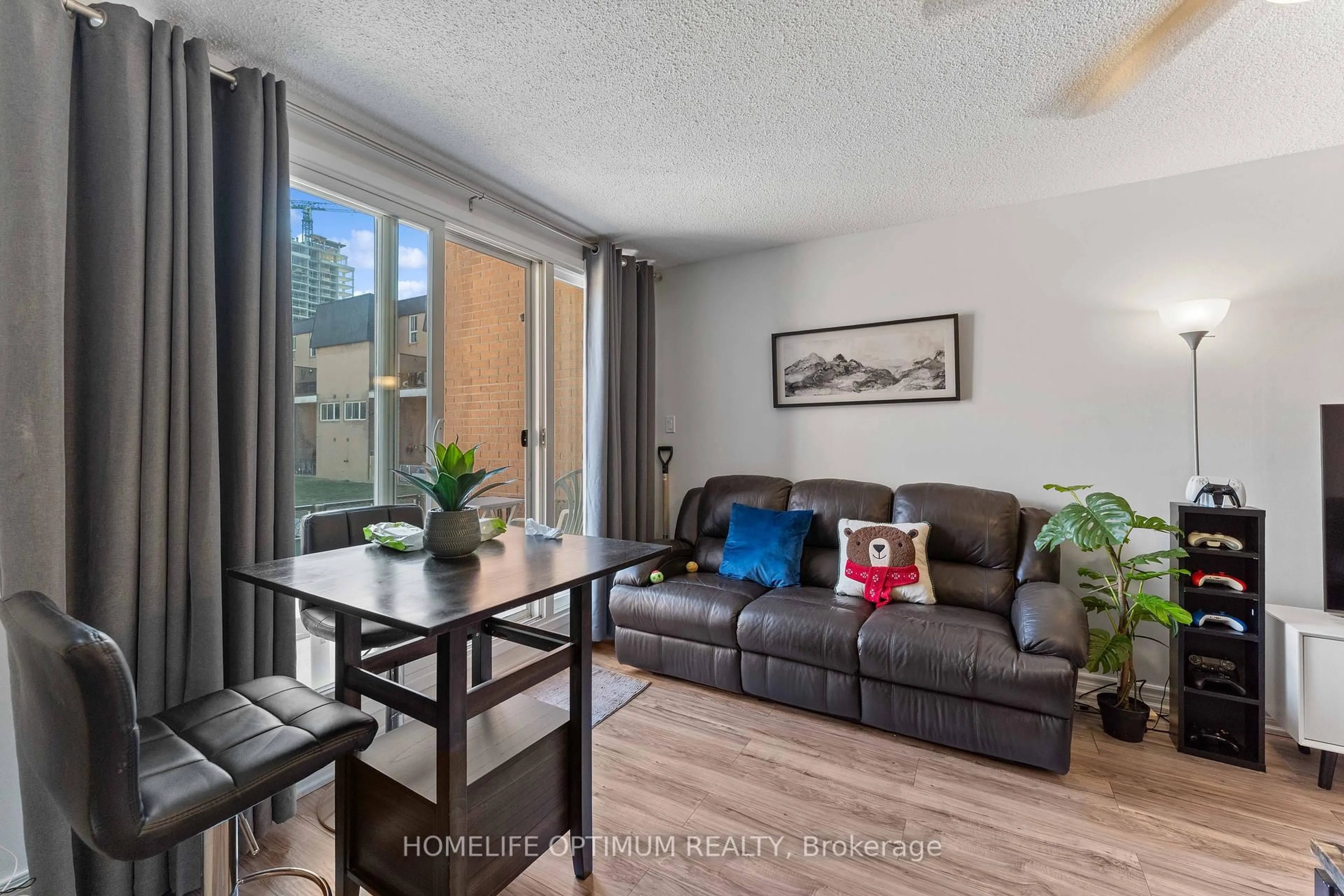 Living room with furniture, wood/laminate floor for 100 Mornelle Crt #1076, Toronto Ontario M1E 4X2
