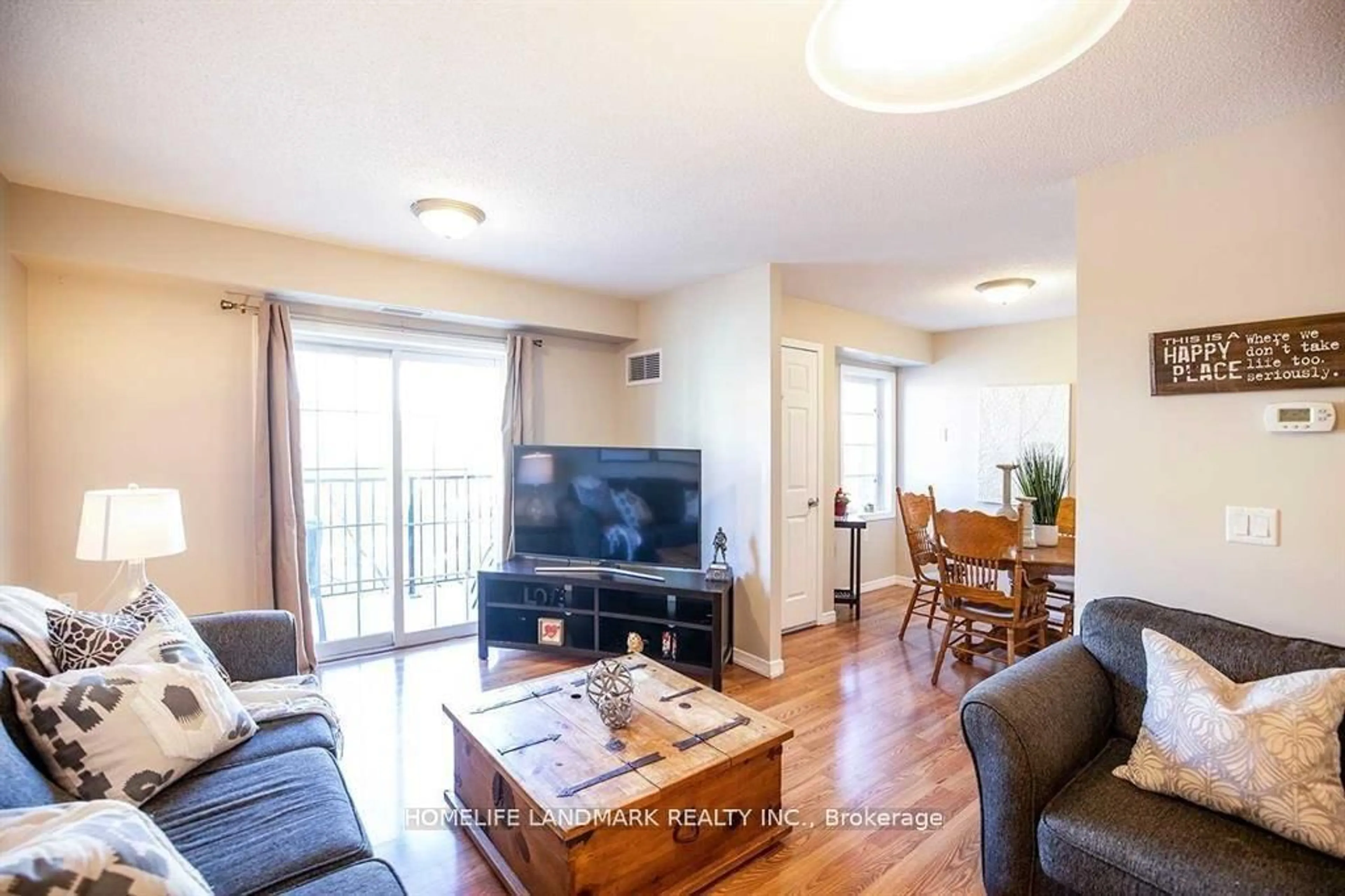 Living room with furniture, wood/laminate floor for 61 Clarington Blvd #213, Clarington Ontario L1C 3K7