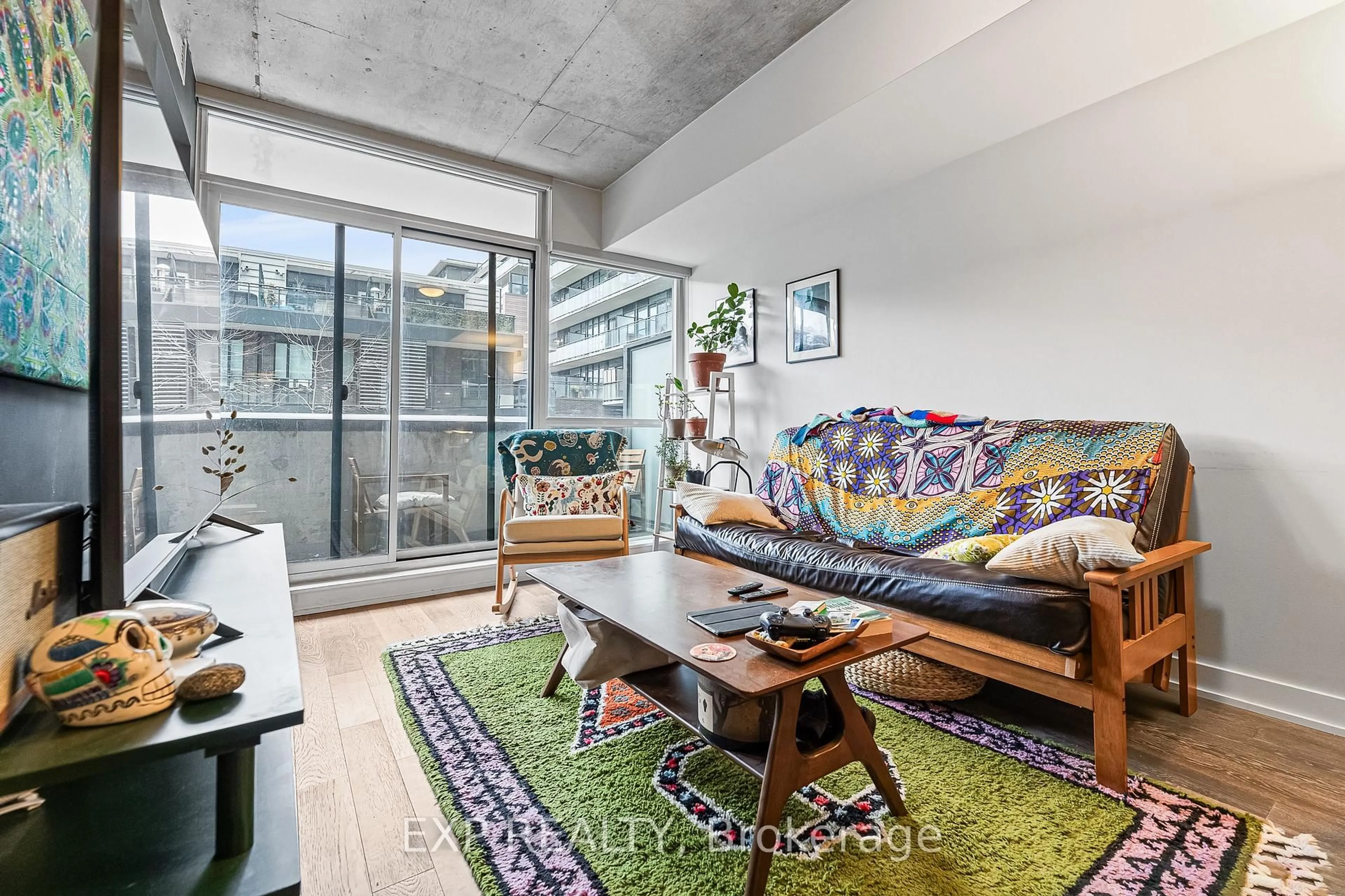 Living room with furniture, cement floor for 1190 Dundas St #225, Toronto Ontario M4M 0C5