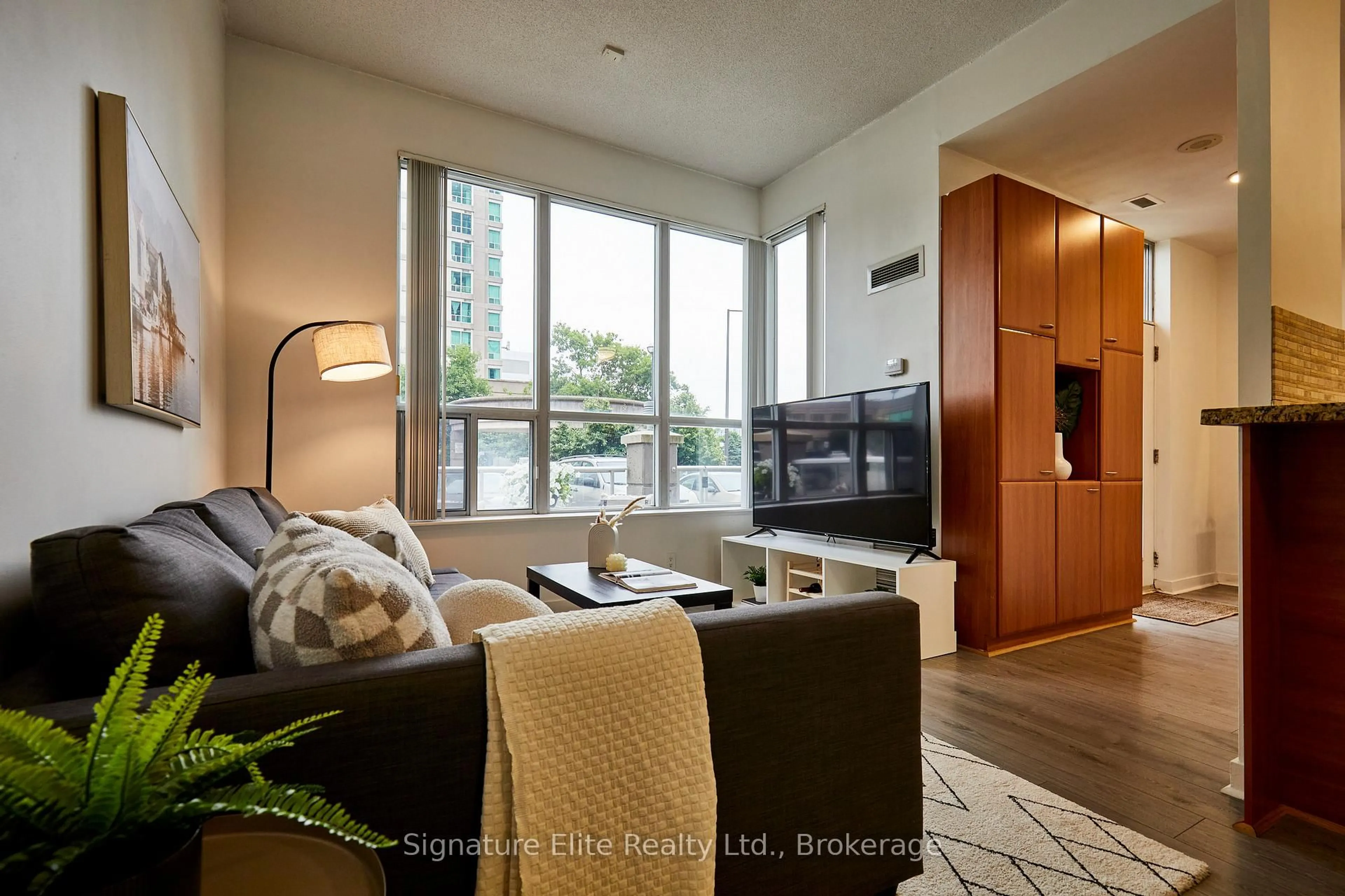 Living room with furniture, wood/laminate floor for 38 Lee Centre Dr #TH128, Toronto Ontario M1H 3J7