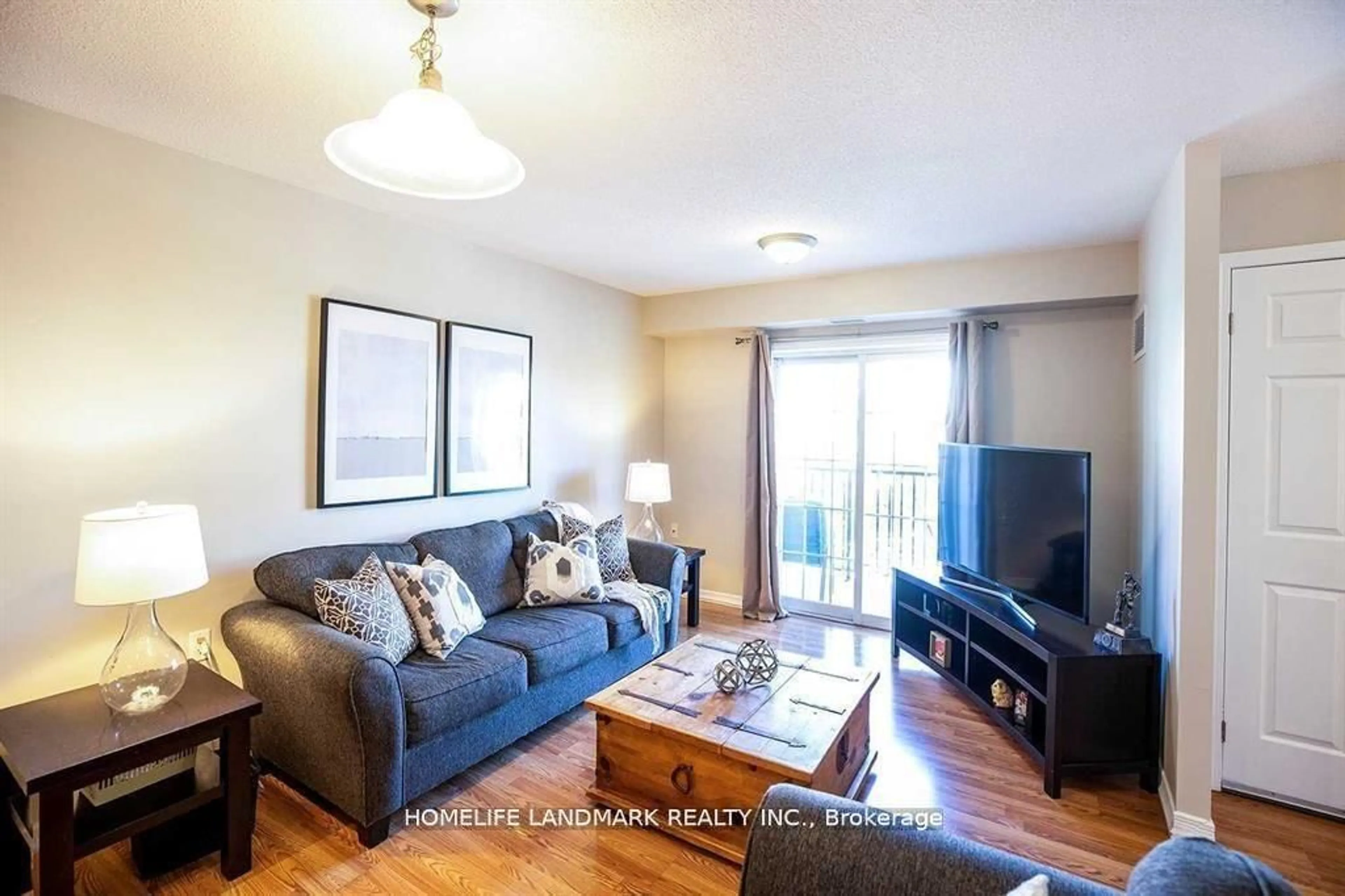 Living room with furniture, wood/laminate floor for 61 Clarington Blvd #213, Clarington Ontario L1C 3K7