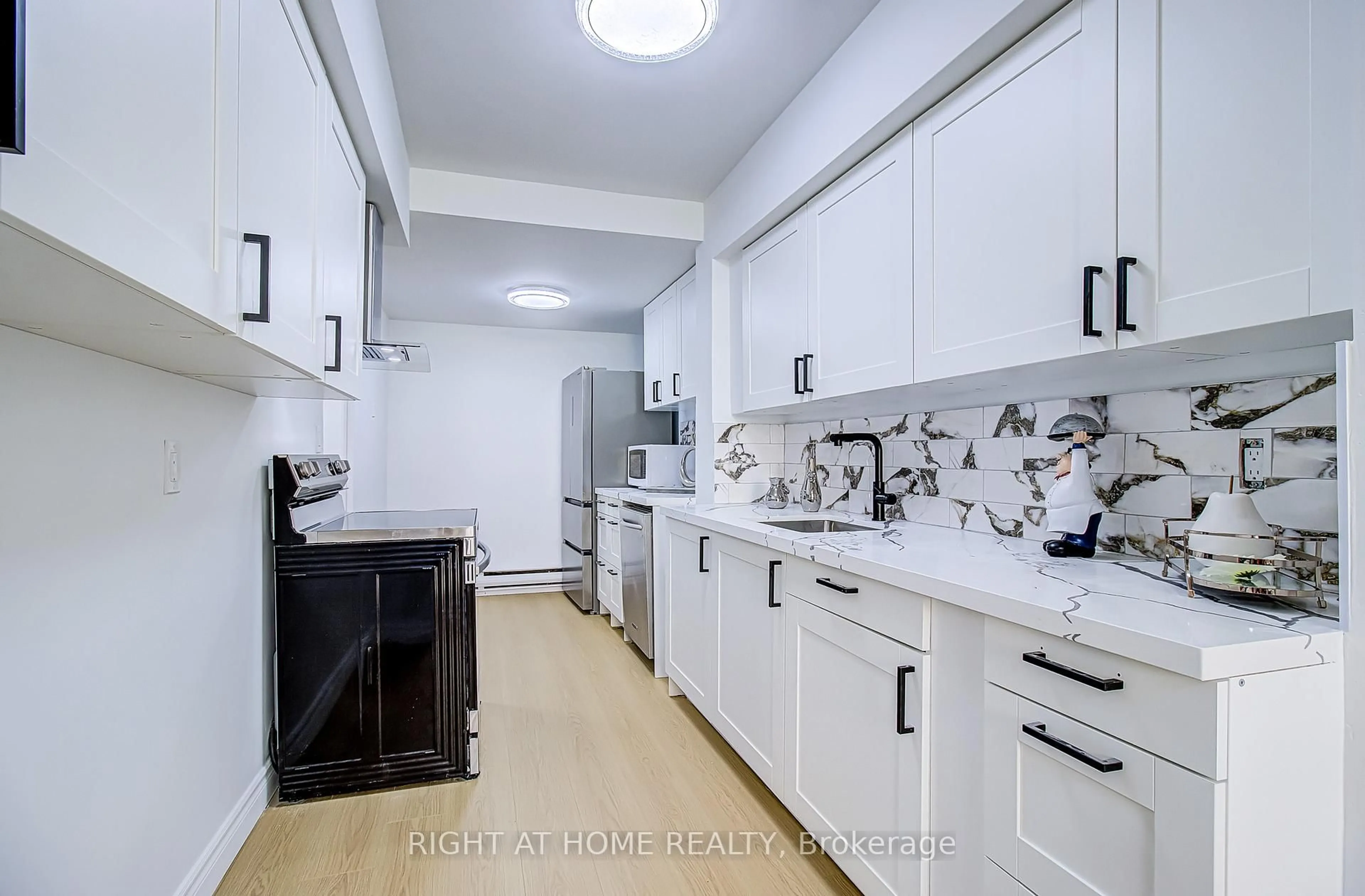 Kitchen with laundary machines, ceramic/tile floor for 8 Crescent Town Rd #409, Toronto Ontario M4C 5L3