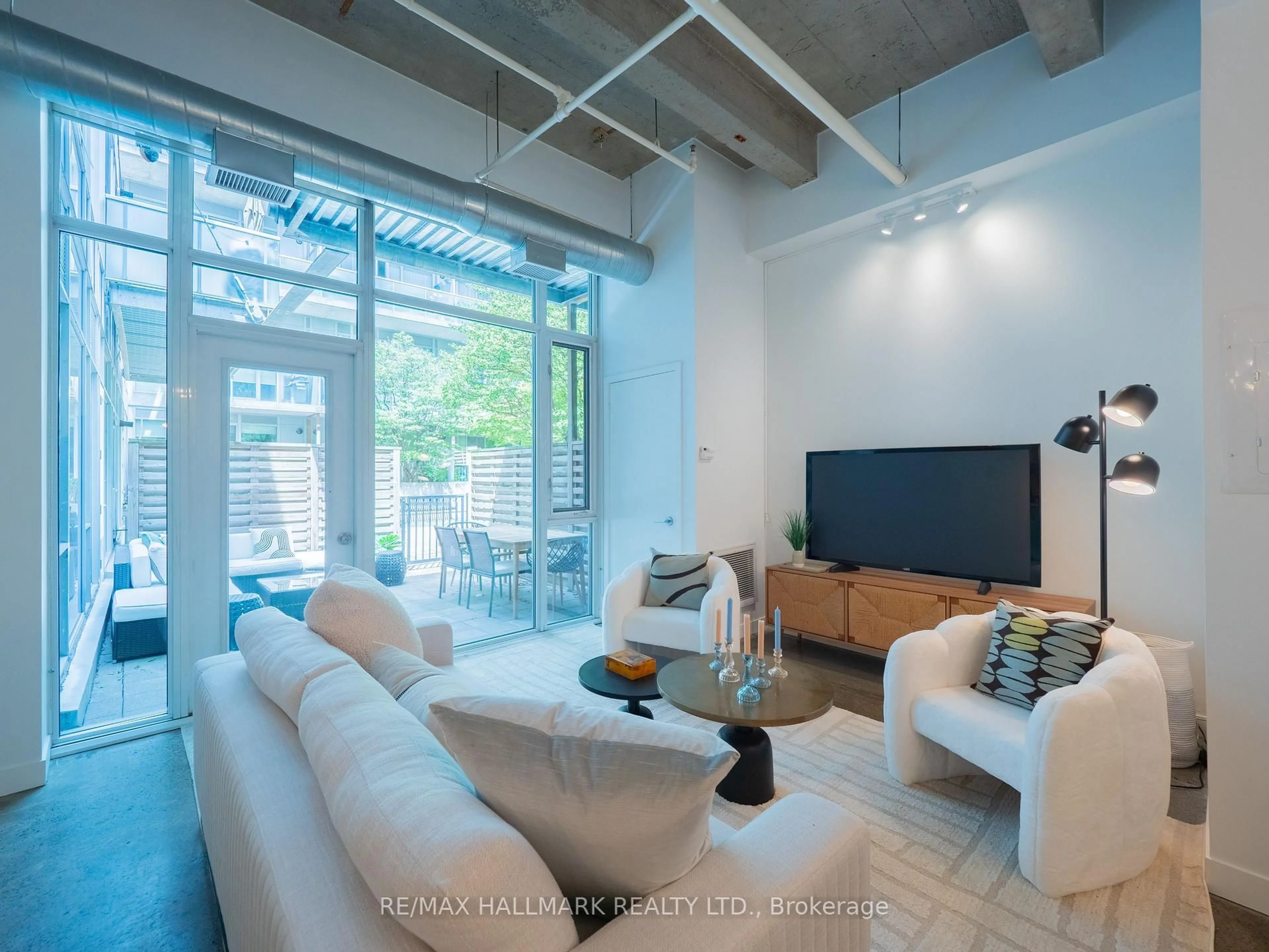 Living room with furniture, cement floor for 201 Carlaw Ave #112, Toronto Ontario M4M 2S3