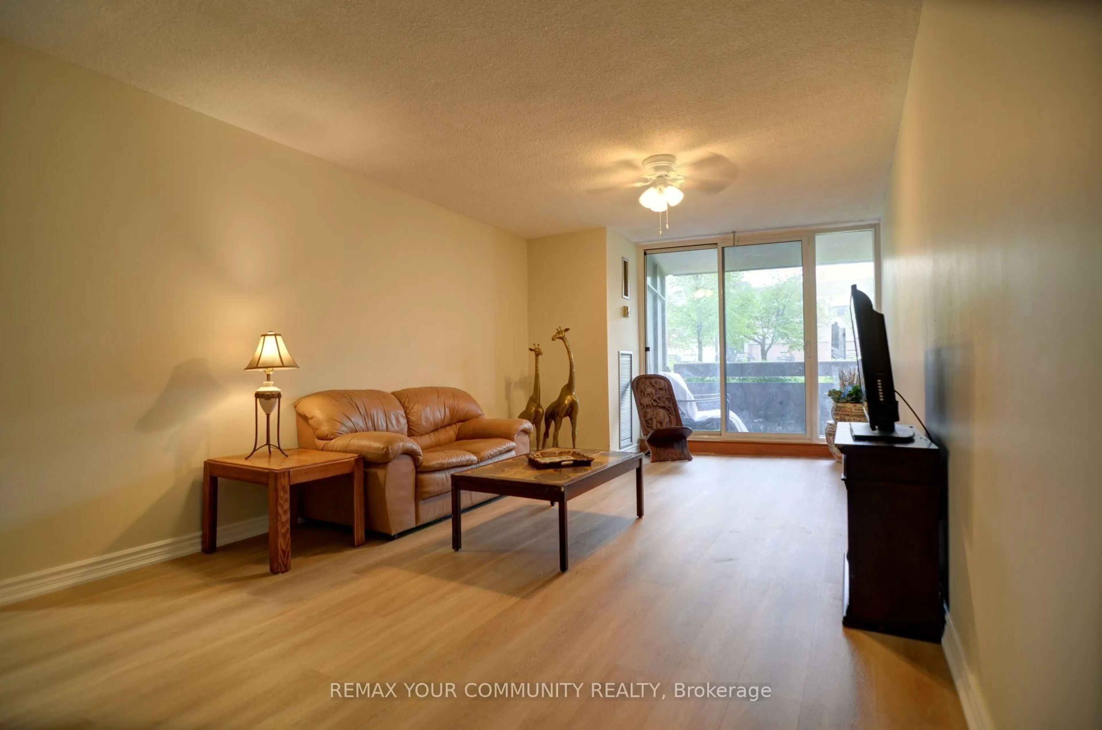 Living room with furniture, wood/laminate floor for 3131 Bridletowne Circ #103, Toronto Ontario M1W 2S9