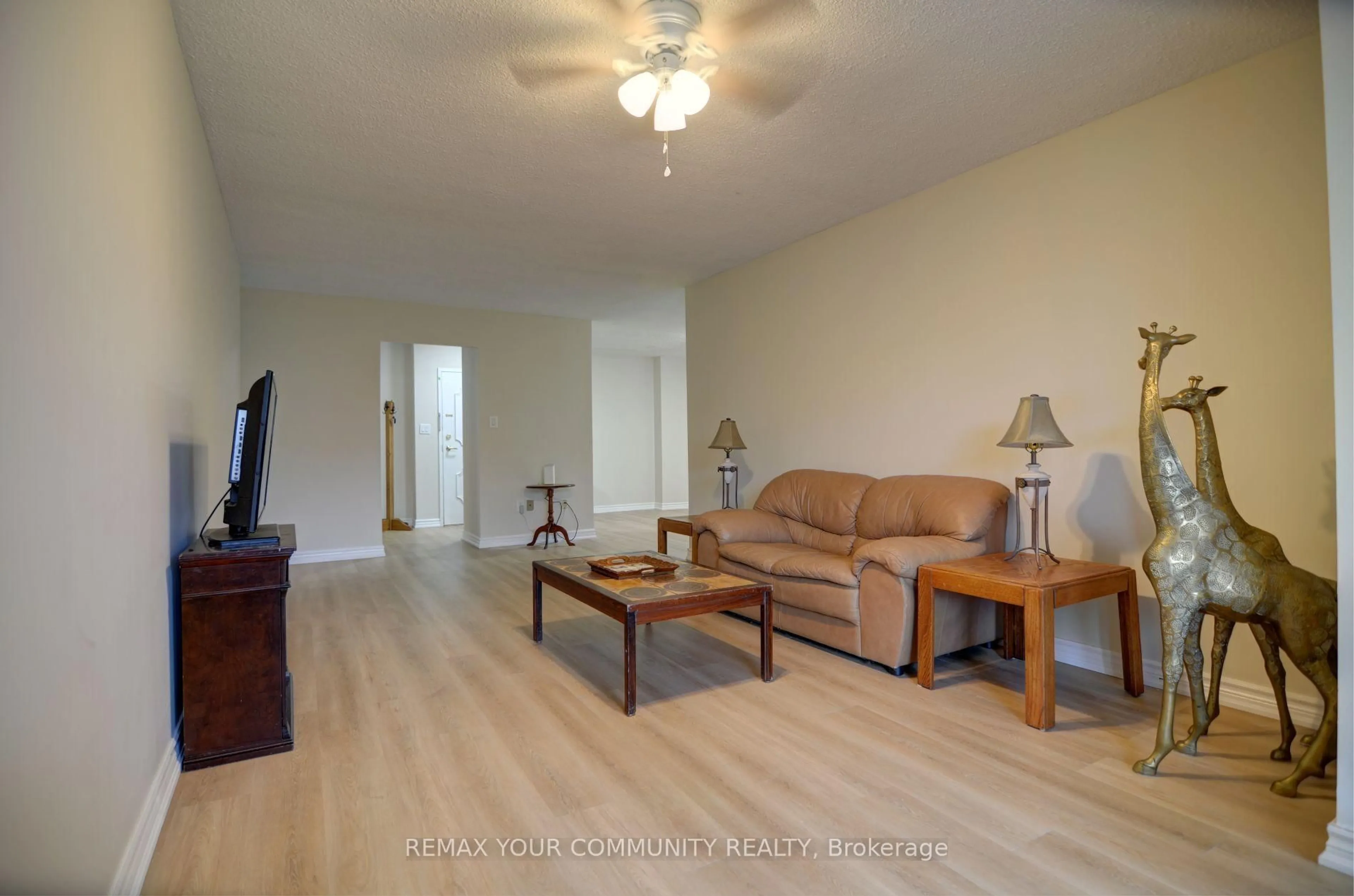 Living room with furniture, wood/laminate floor for 3131 Bridletowne Circ #103, Toronto Ontario M1W 2S9
