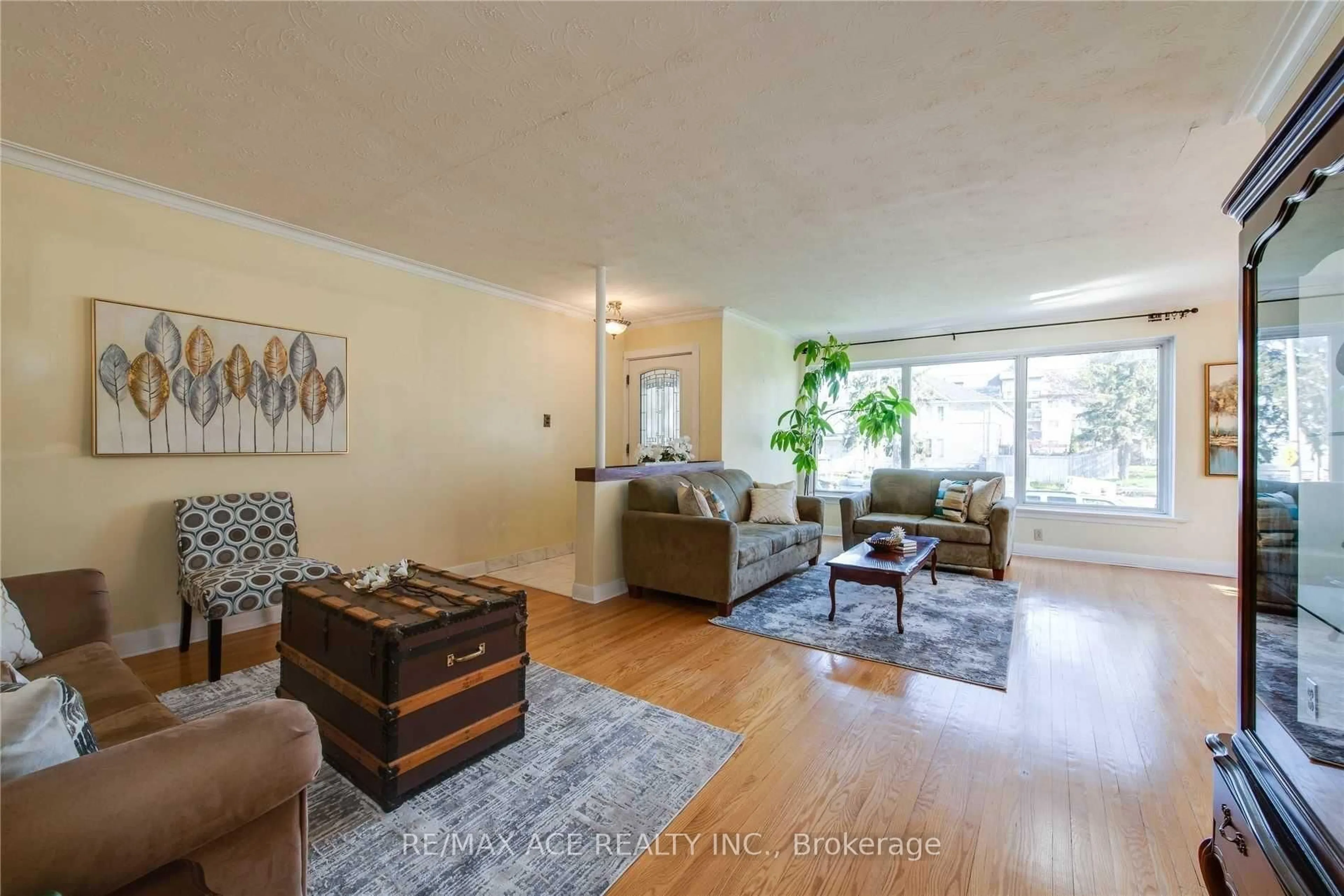 Living room with furniture, wood/laminate floor for 3715 St Clair Ave, Toronto Ontario M1M 1T5