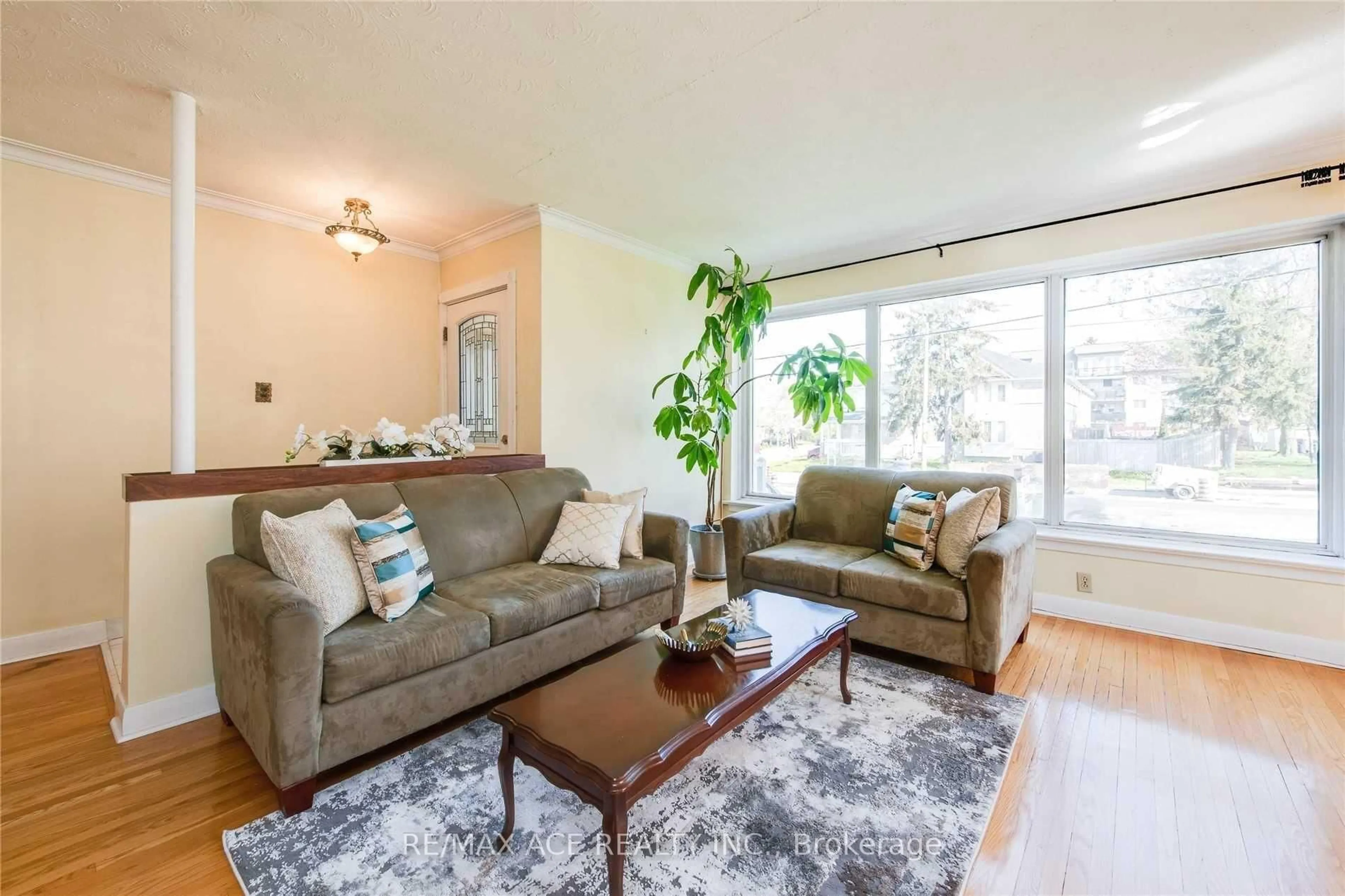 Living room with furniture, wood/laminate floor for 3715 St Clair Ave, Toronto Ontario M1M 1T5