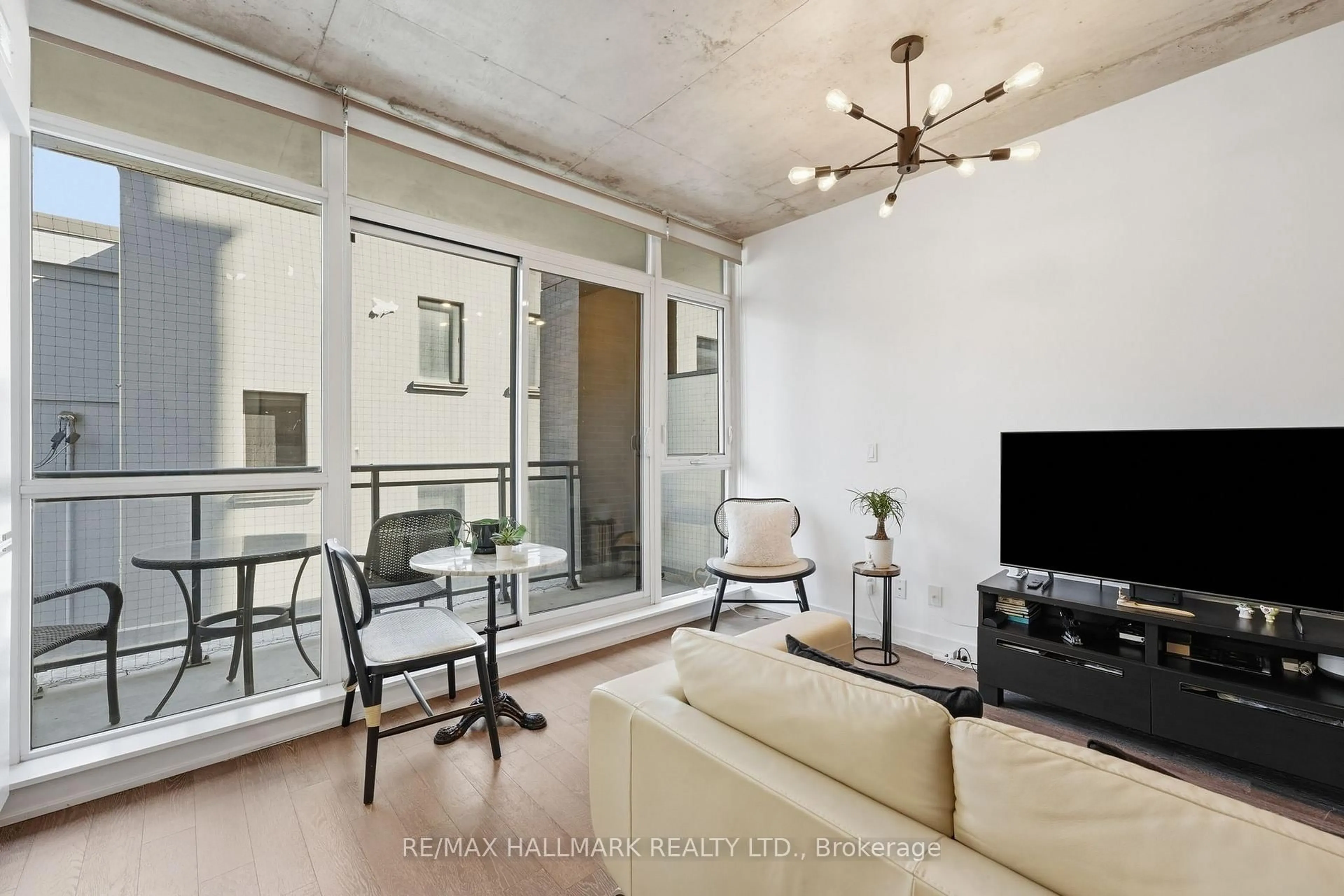 Living room with furniture, cement floor for 1190 Dundas St #323, Toronto Ontario M4M 0C5