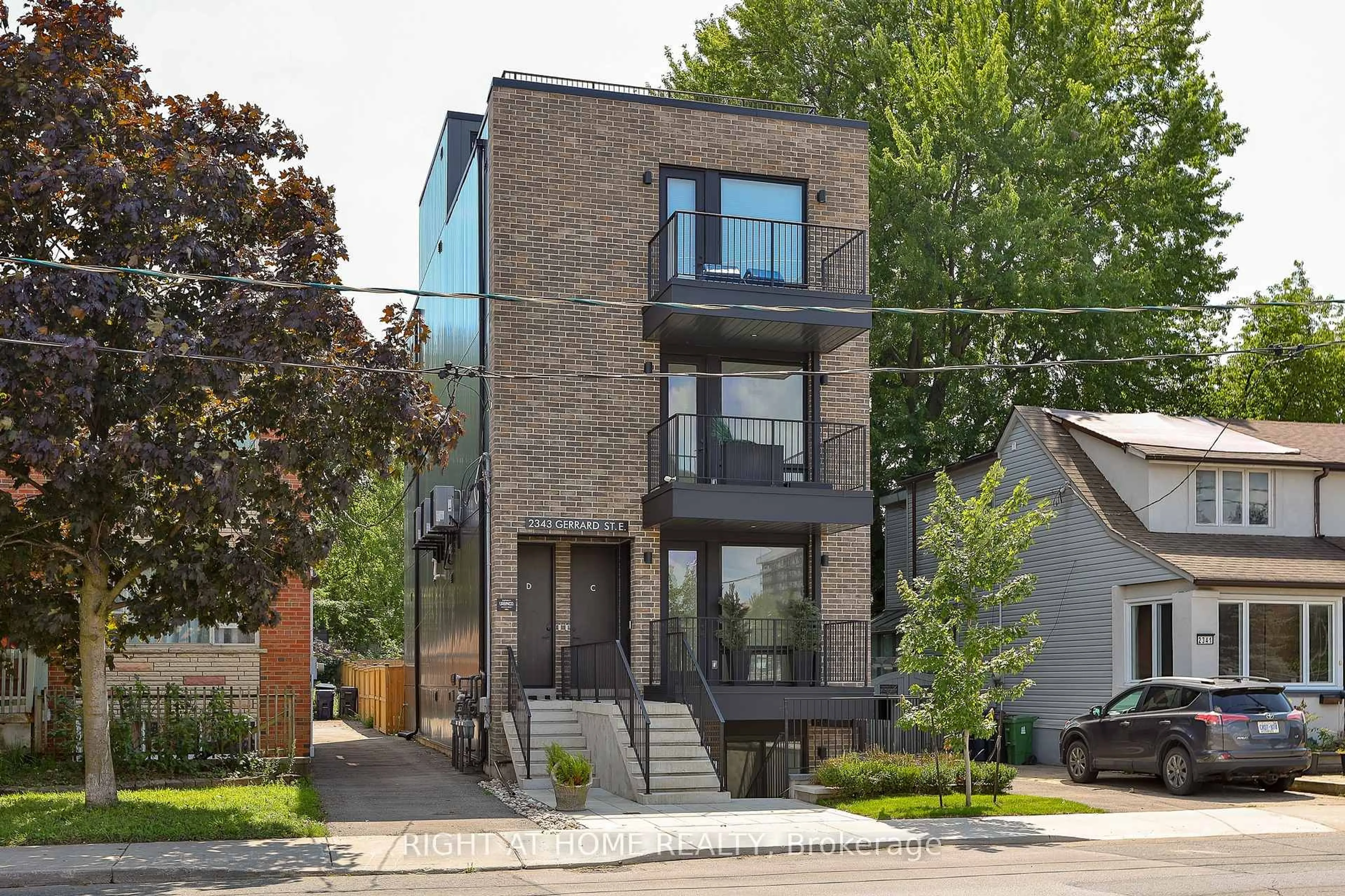 Home with brick exterior material, street for 2343 Gerrard St #Ground Floor, Toronto Ontario M4E 2E6