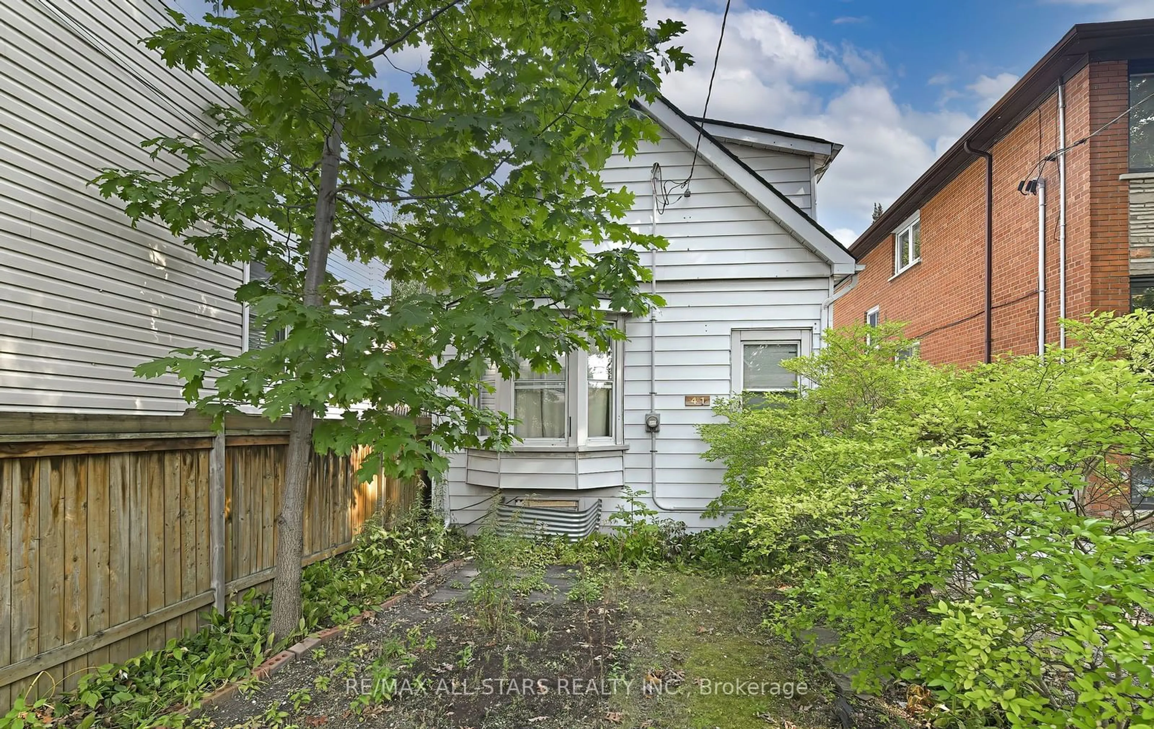 A pic from exterior of the house or condo, the fenced backyard for 41 Norwood Rd, Toronto Ontario M4E 2S2