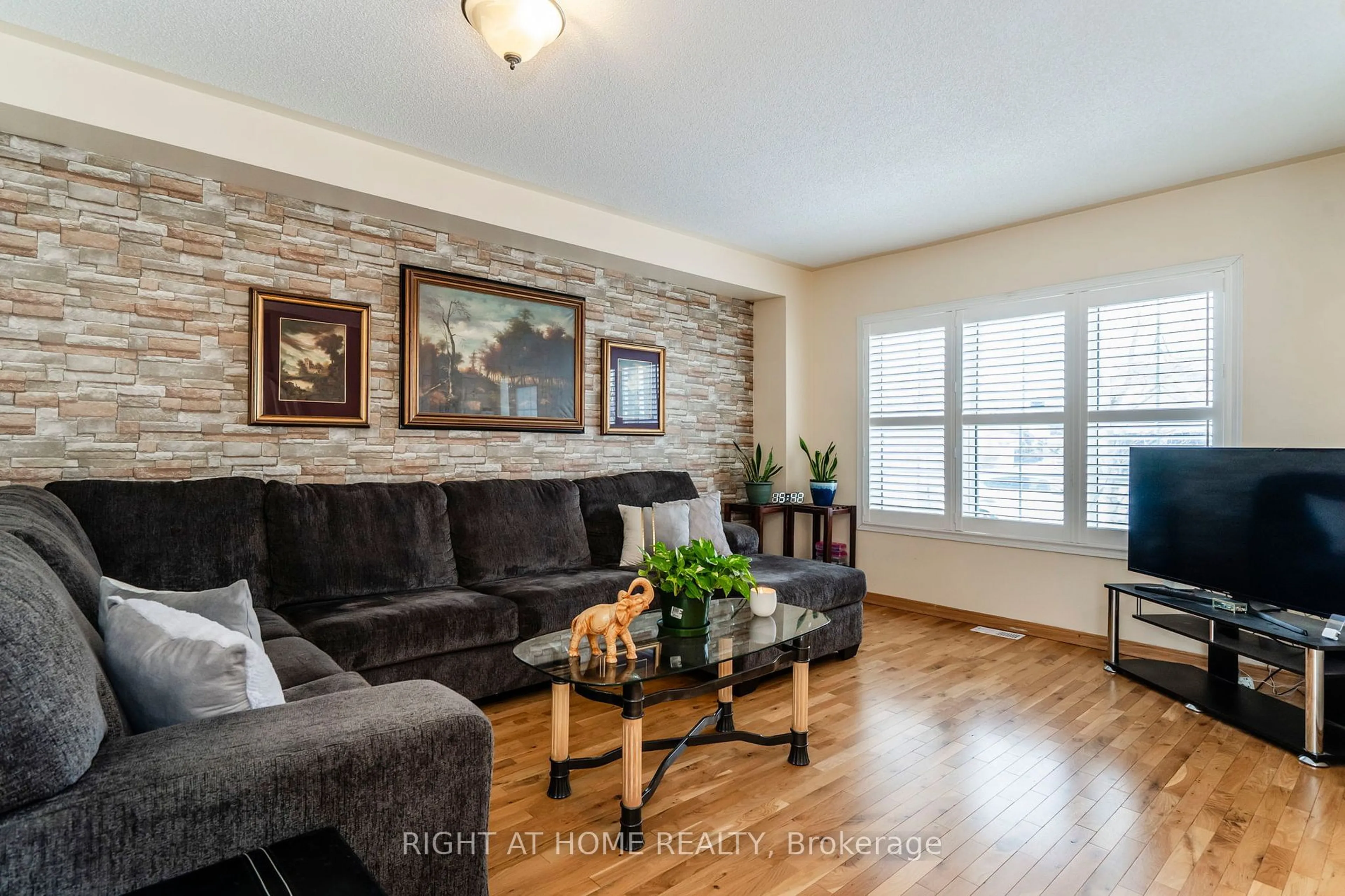 Living room with furniture, wood/laminate floor for 14 Gold Park Gate, Essa Ontario L3W 0C2