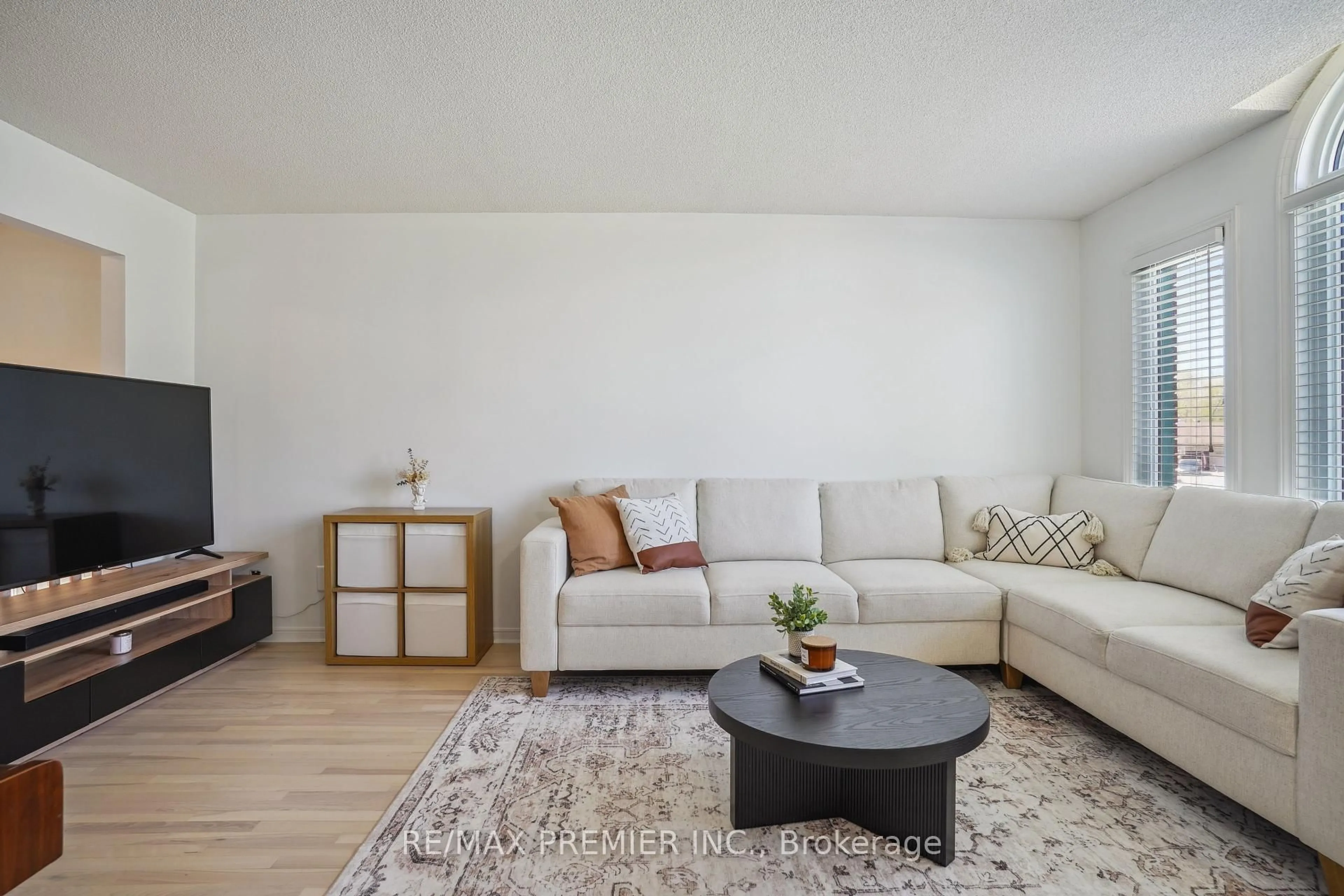 Living room with furniture, wood/laminate floor for 28 Edenbridge Dr, Essa Ontario L3W 0K7