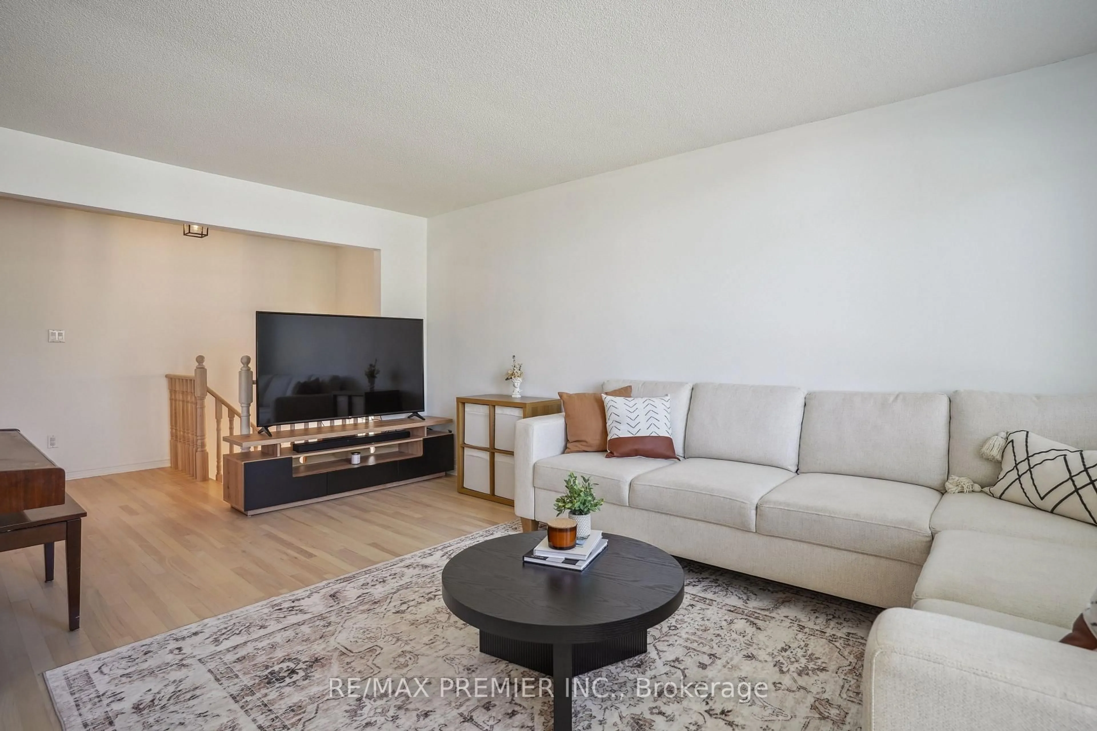 Living room with furniture, wood/laminate floor for 28 Edenbridge Dr, Essa Ontario L3W 0K7