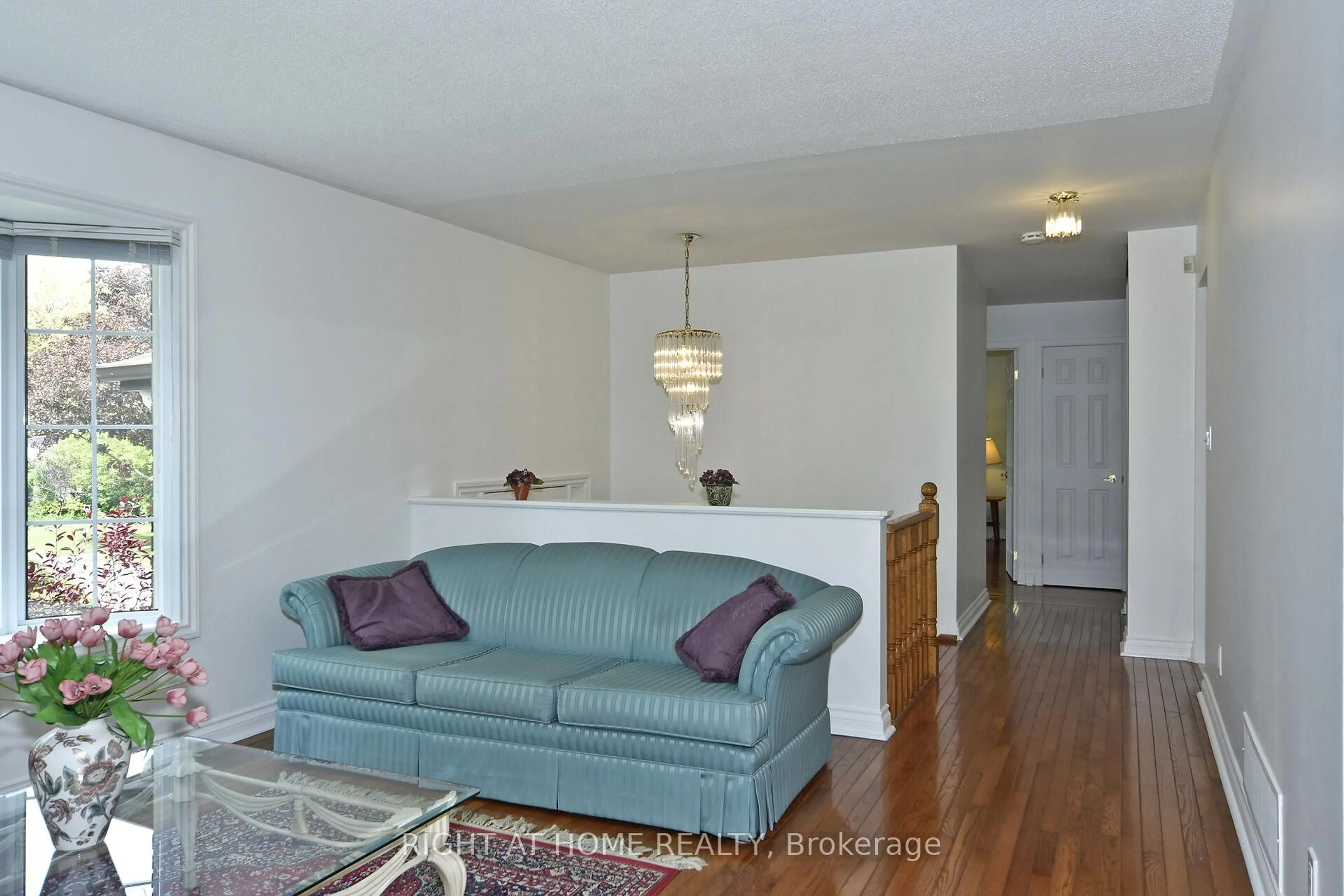 Living room with furniture, wood/laminate floor for 102 Romfield Crct, Markham Ontario L3T 3H6