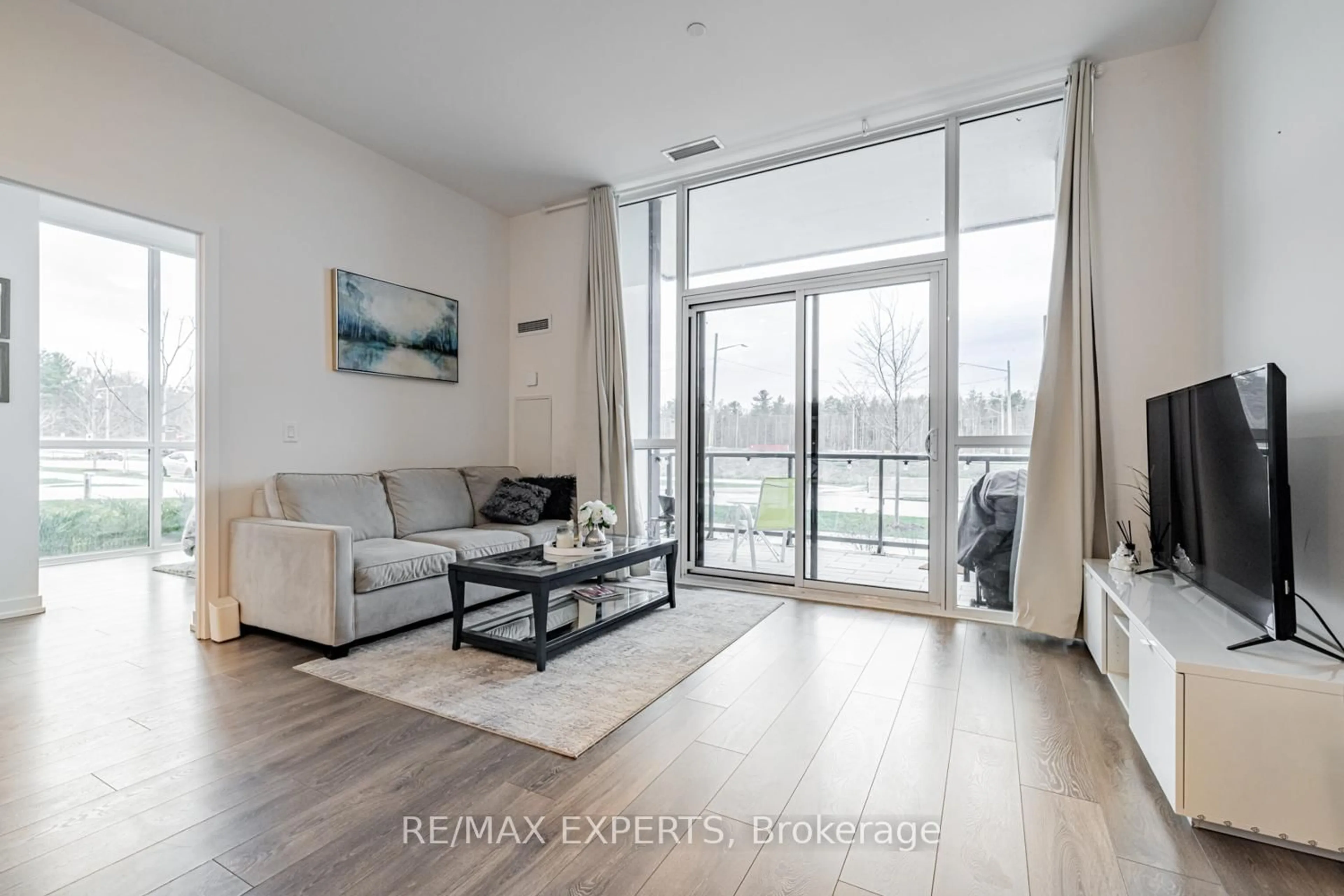 Living room with furniture, wood/laminate floor for 415 Sea Ray Ave #105, Innisfil Ontario L9S 0R5